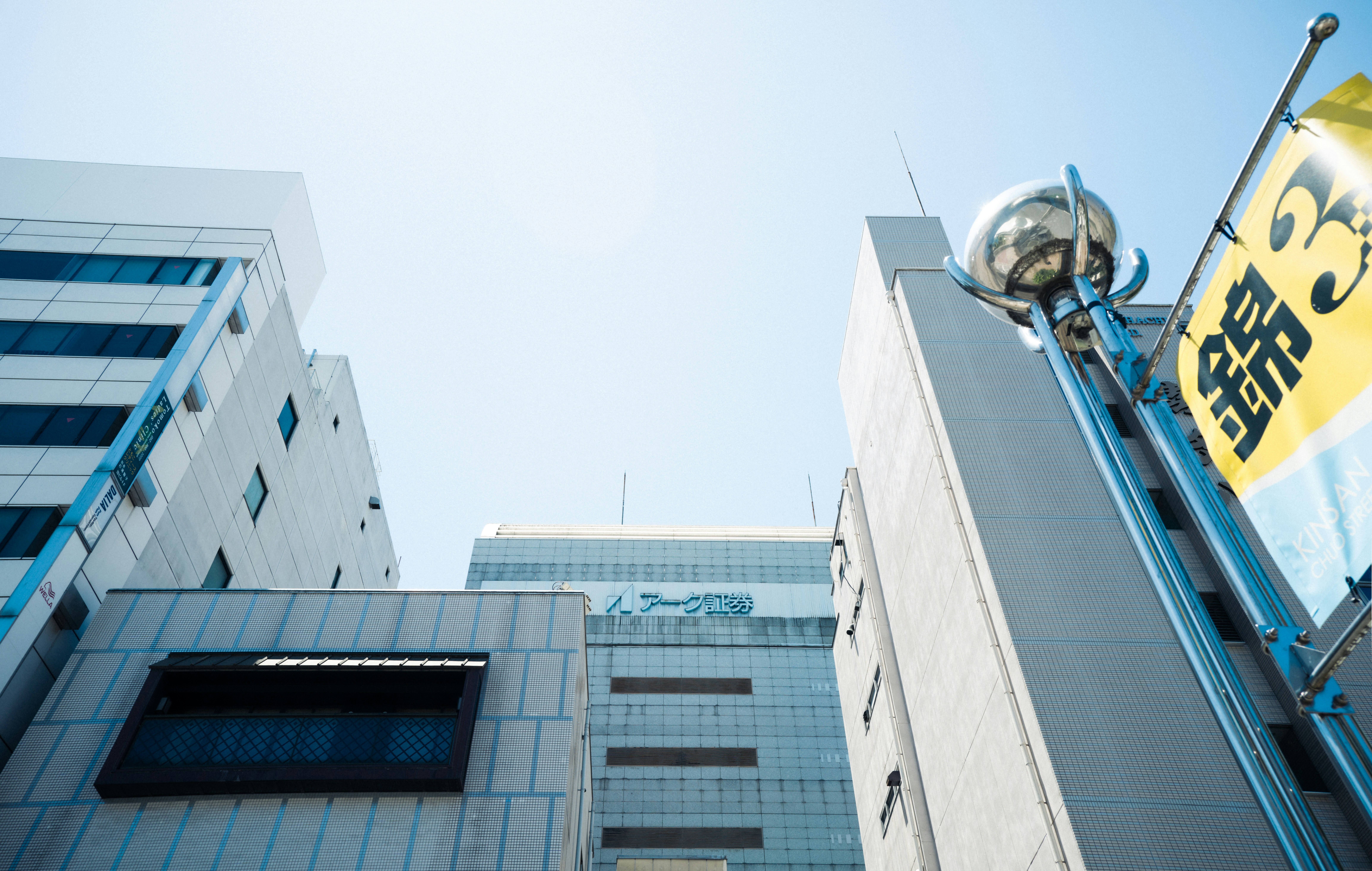 Modern buildings with a bright sky and japanese flag.