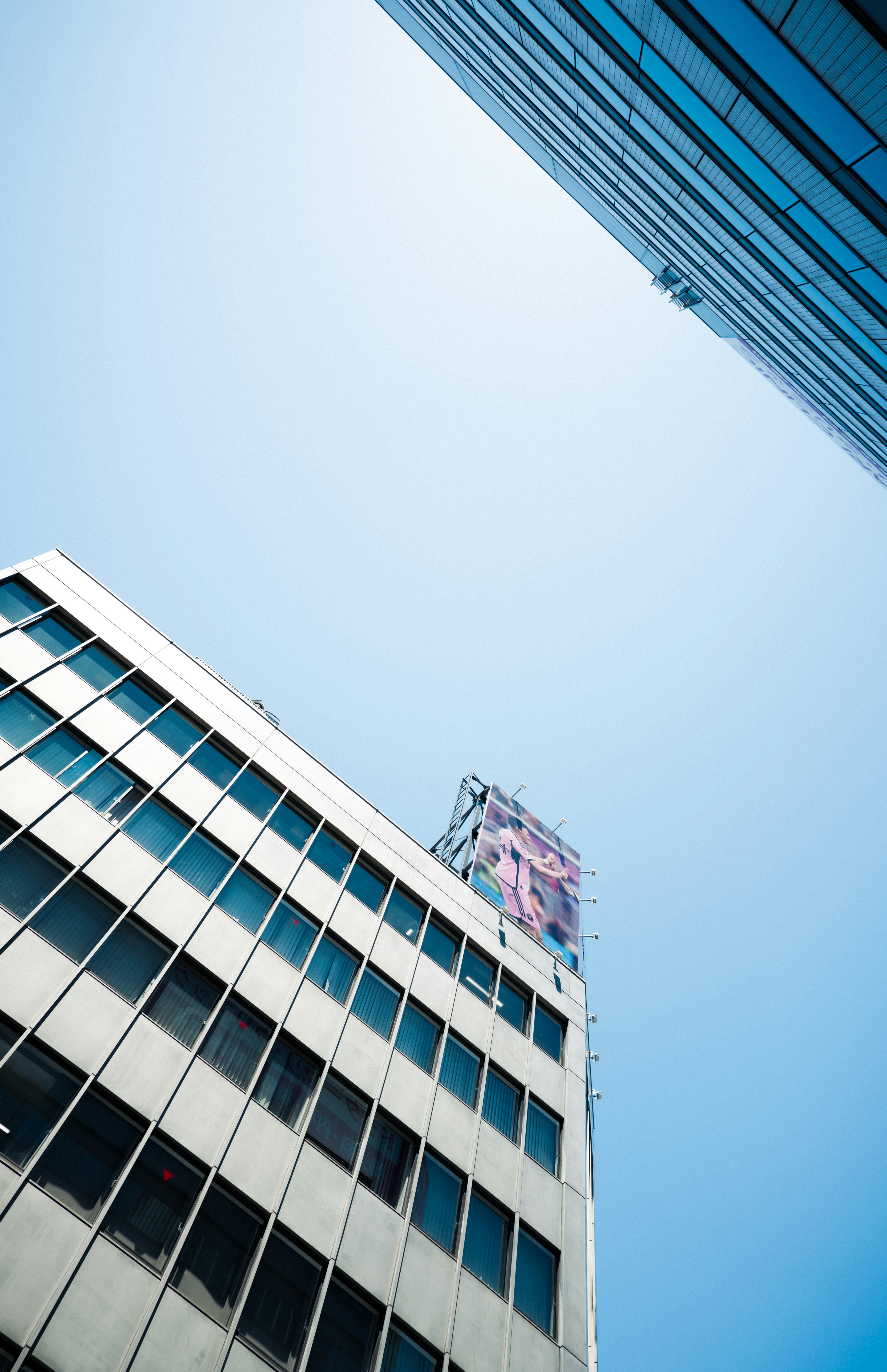 Modern buildings reaching towards a bright blue sky.
