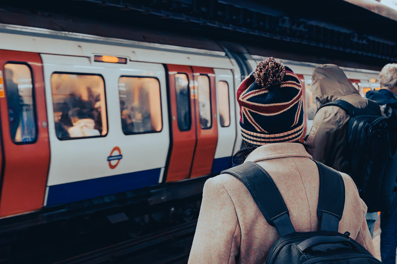 Passengers waiting on a London Underground platform as a train approaches