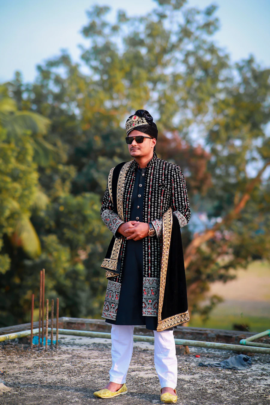 Man wearing a black and gold embroidered kurta with traditional Punjabi jutti