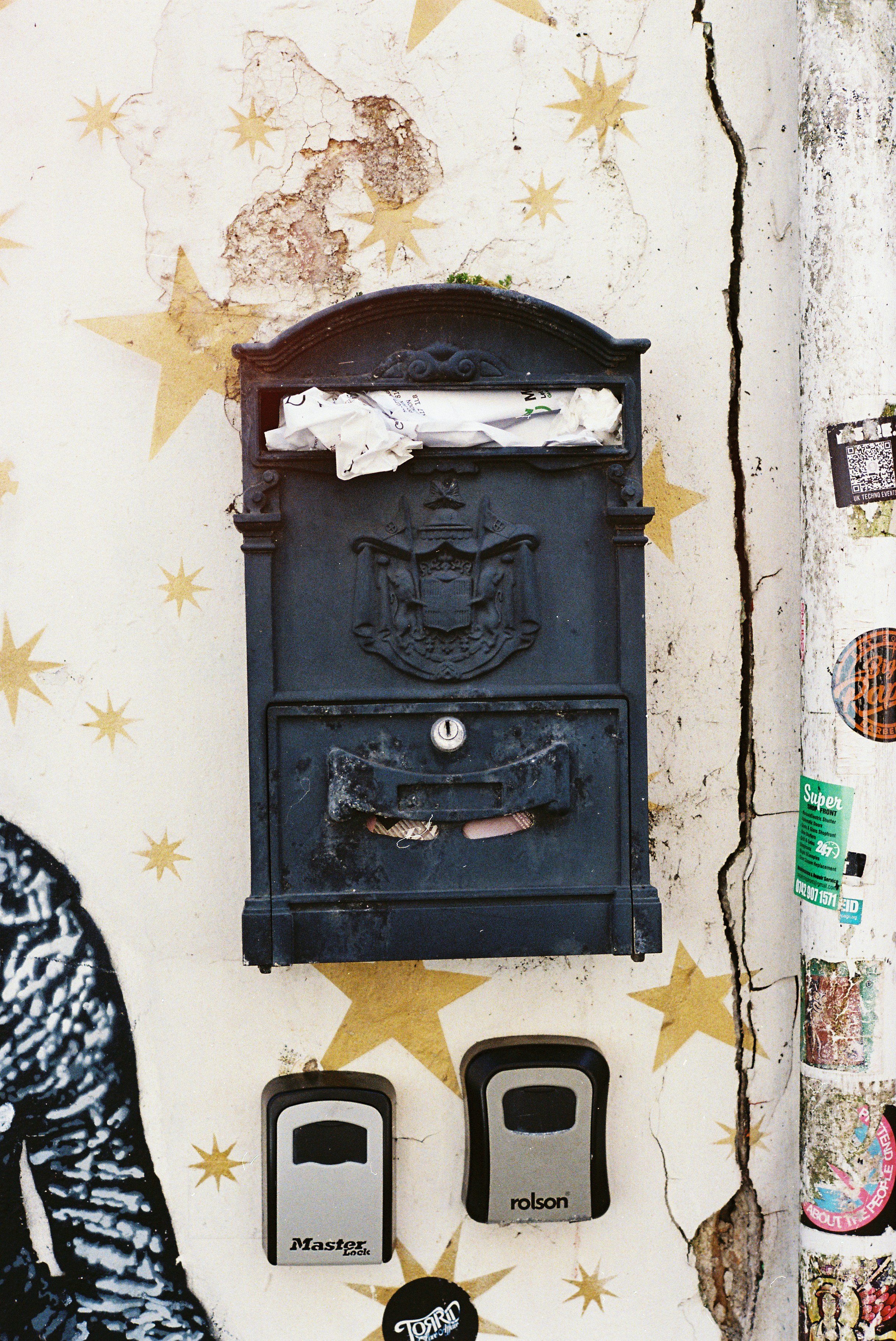 Vintage black mailbox on a star-covered, weathered wall