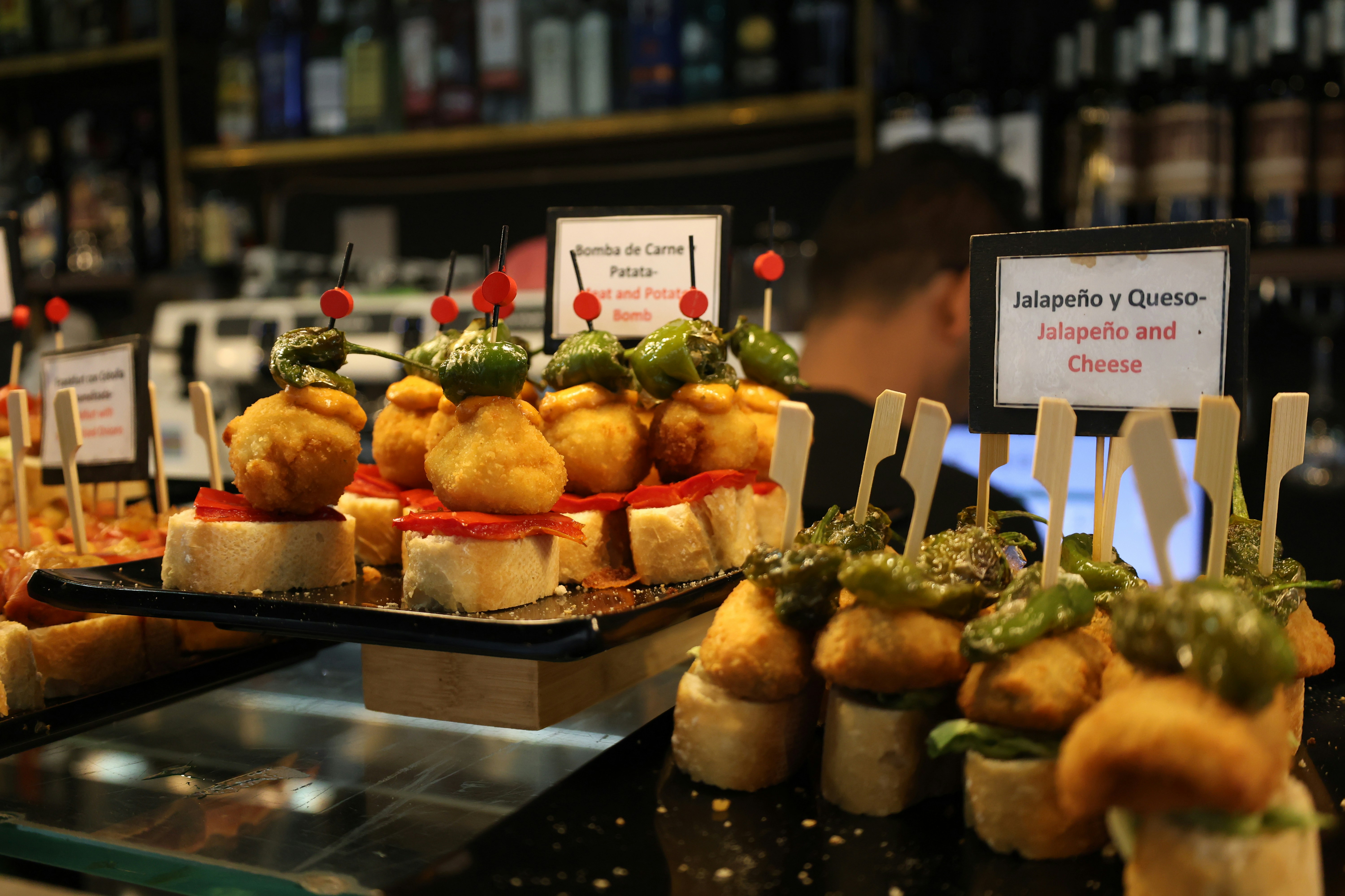 Assorted Spanish pintxos and small plates laid out along a marble bar counter