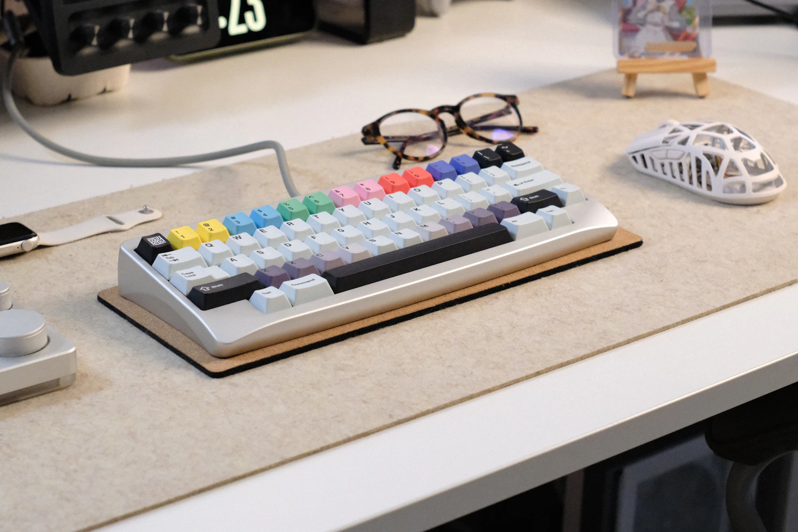 Mechanical keyboard, smartwatch and wireless mouse arranged on a refined desk setup
