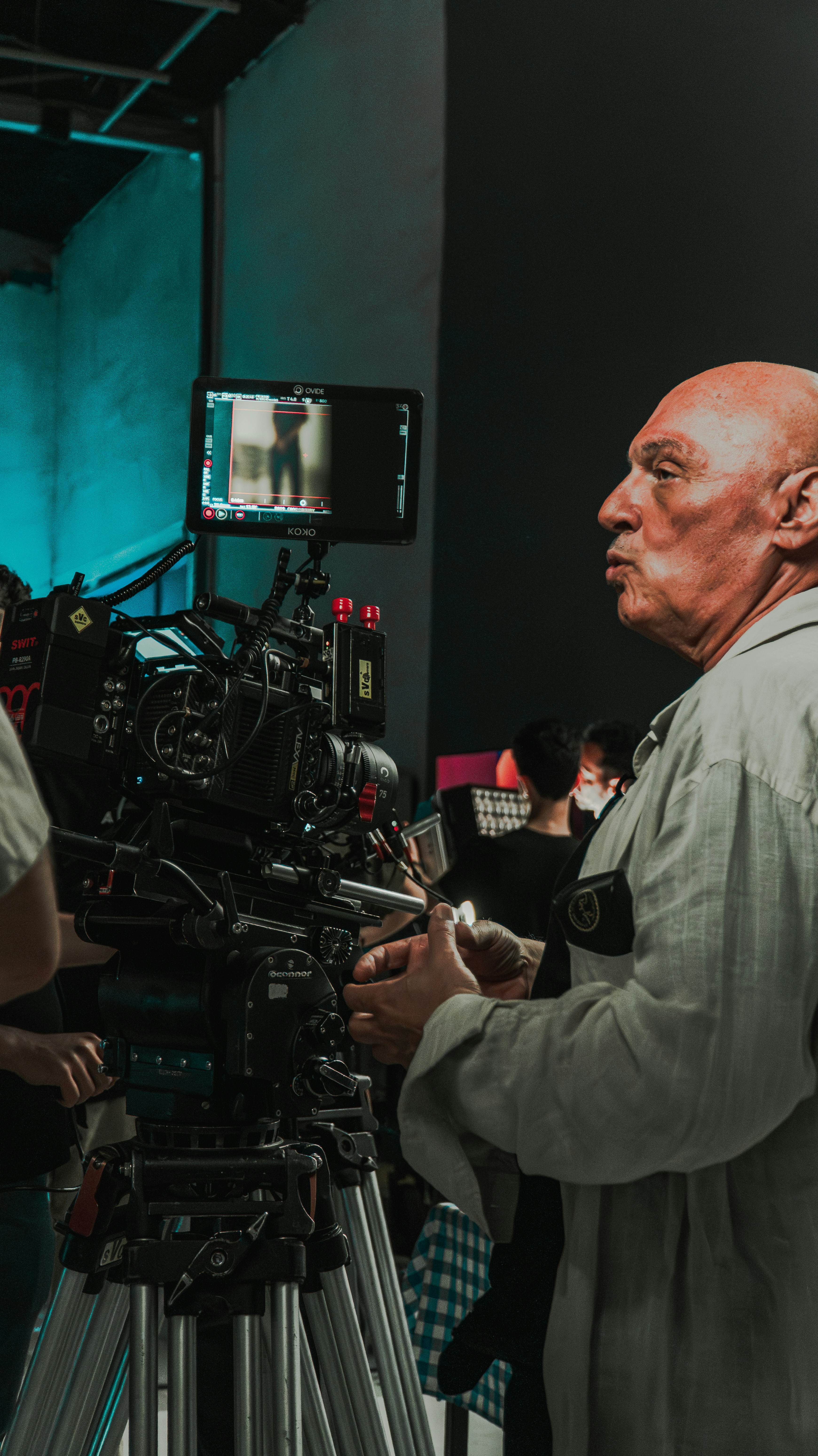 Bald man on a film set with a professional camera.