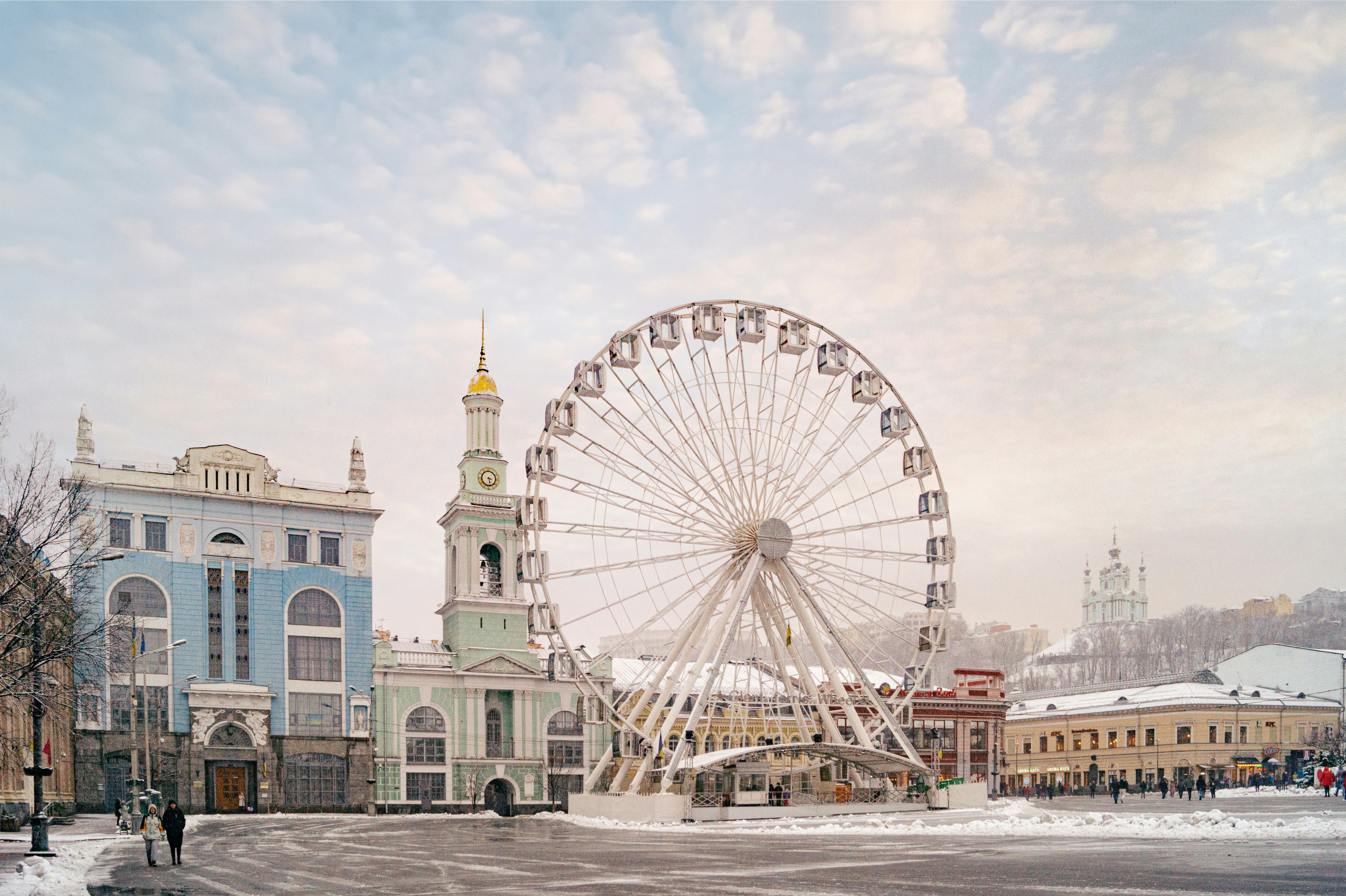 Riesenrad und Kirche in einer verschneiten Stadtlandschaft.