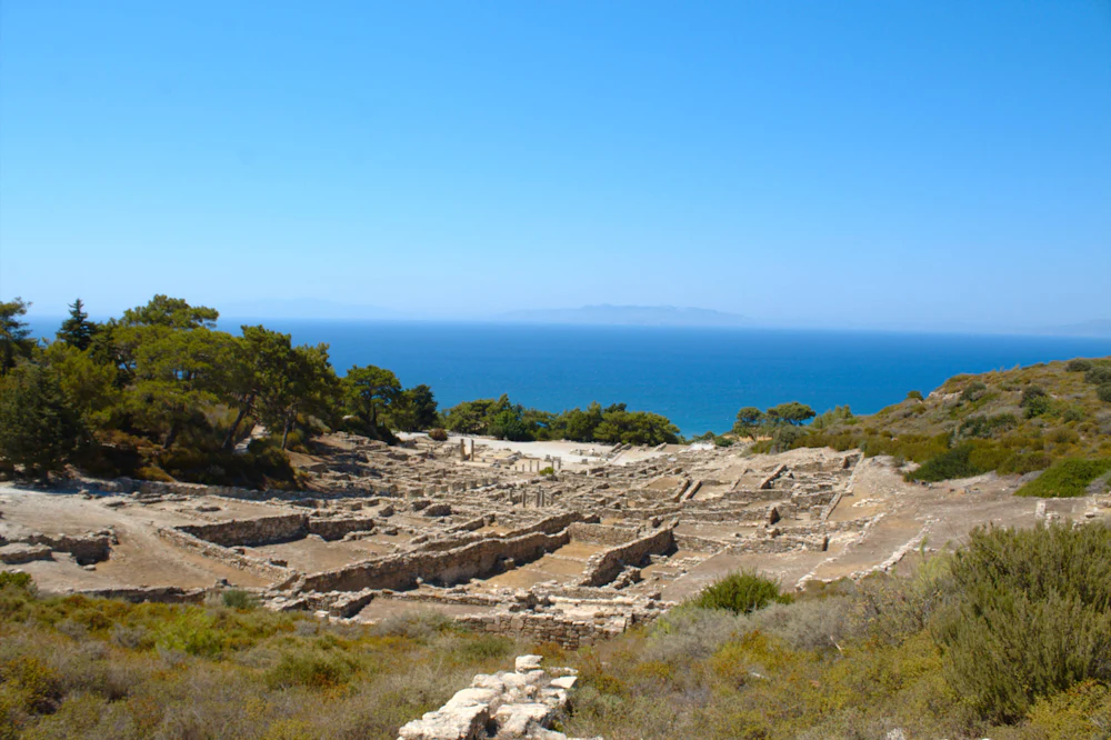 Ancient stone ruins standing above a blue sea.