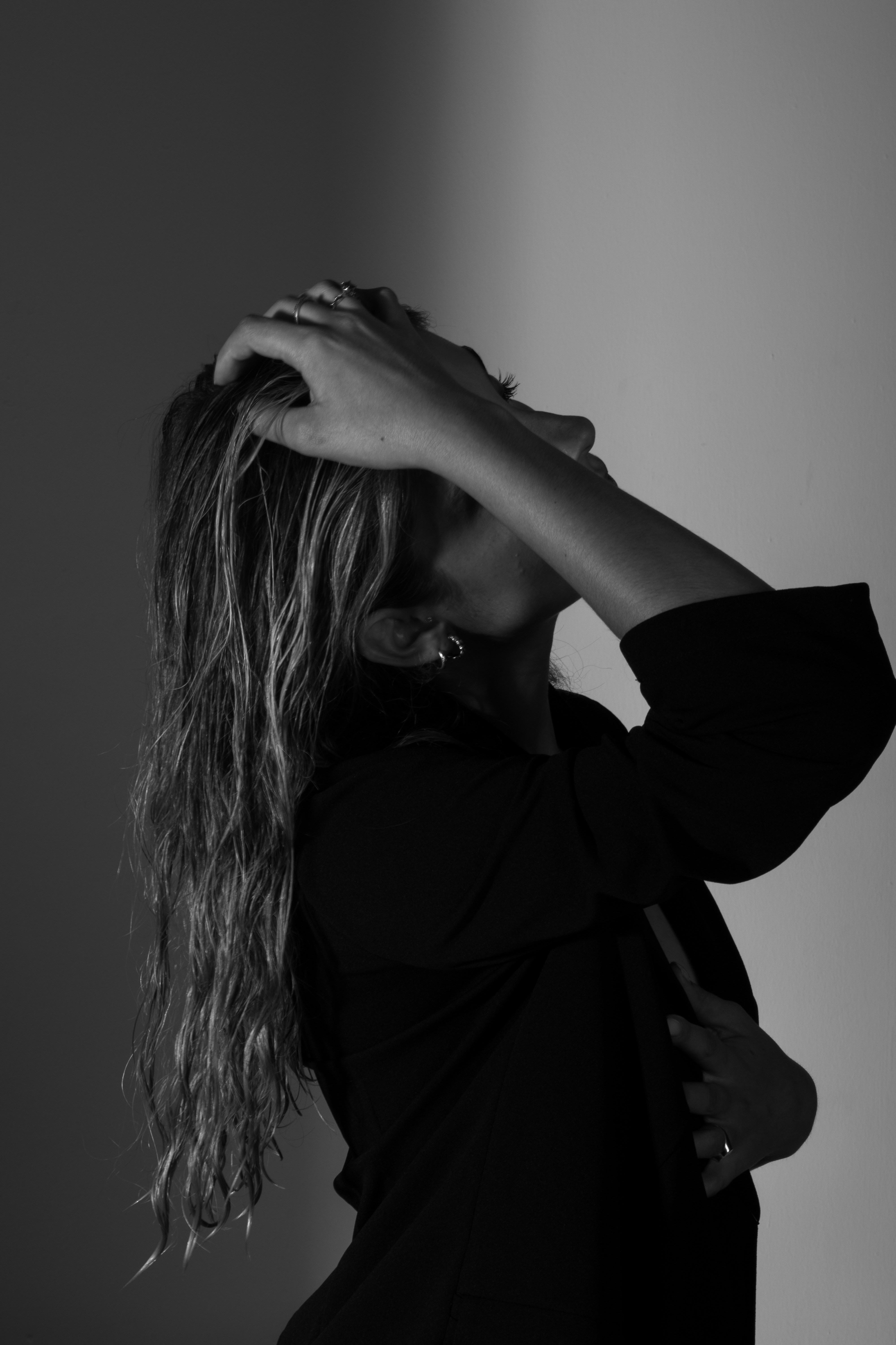 Woman in profile with hand in long, wavy hair