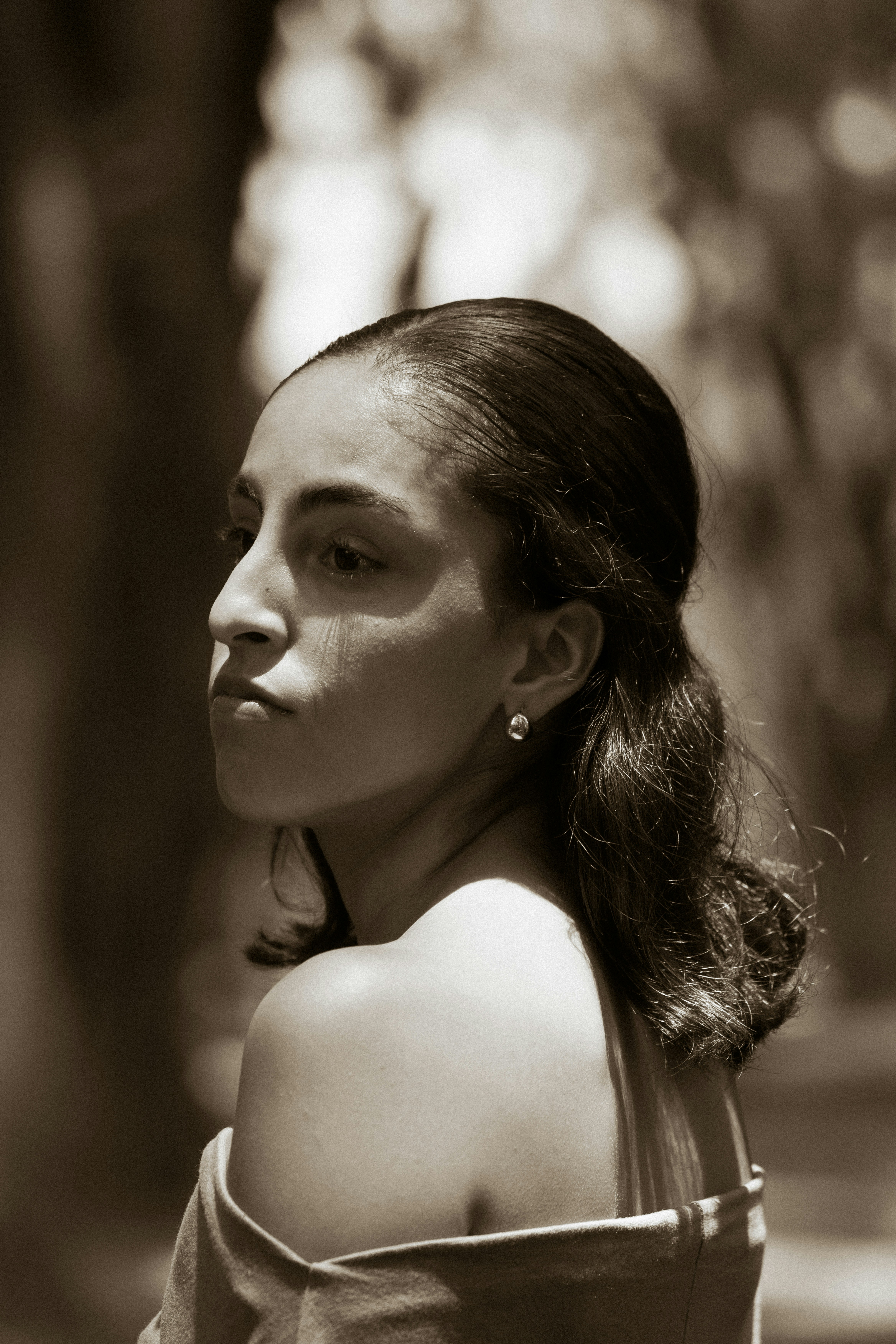 Sepia-toned woman looking over her shoulder with soft lighting