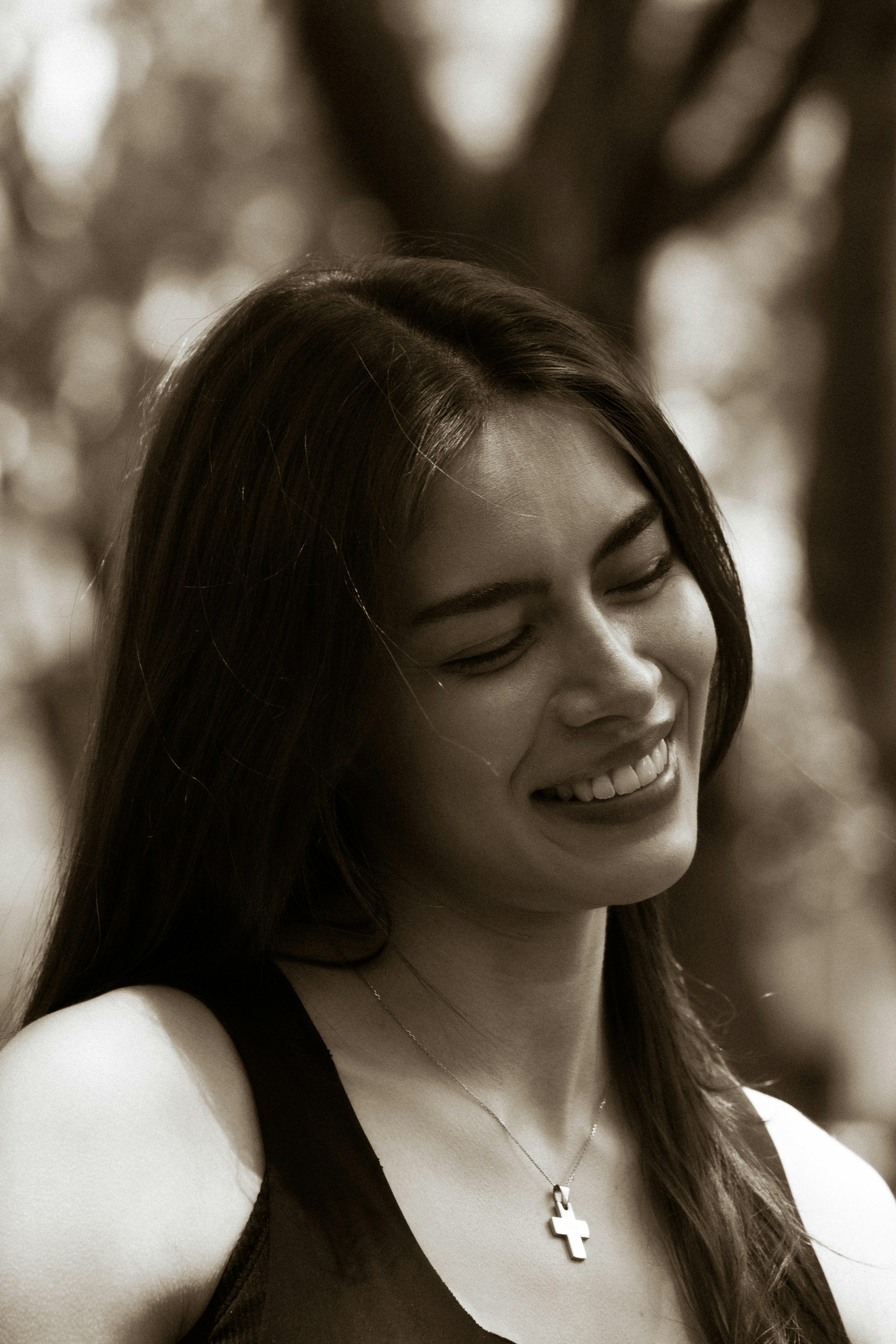 Smiling woman with closed eyes in sepia tone