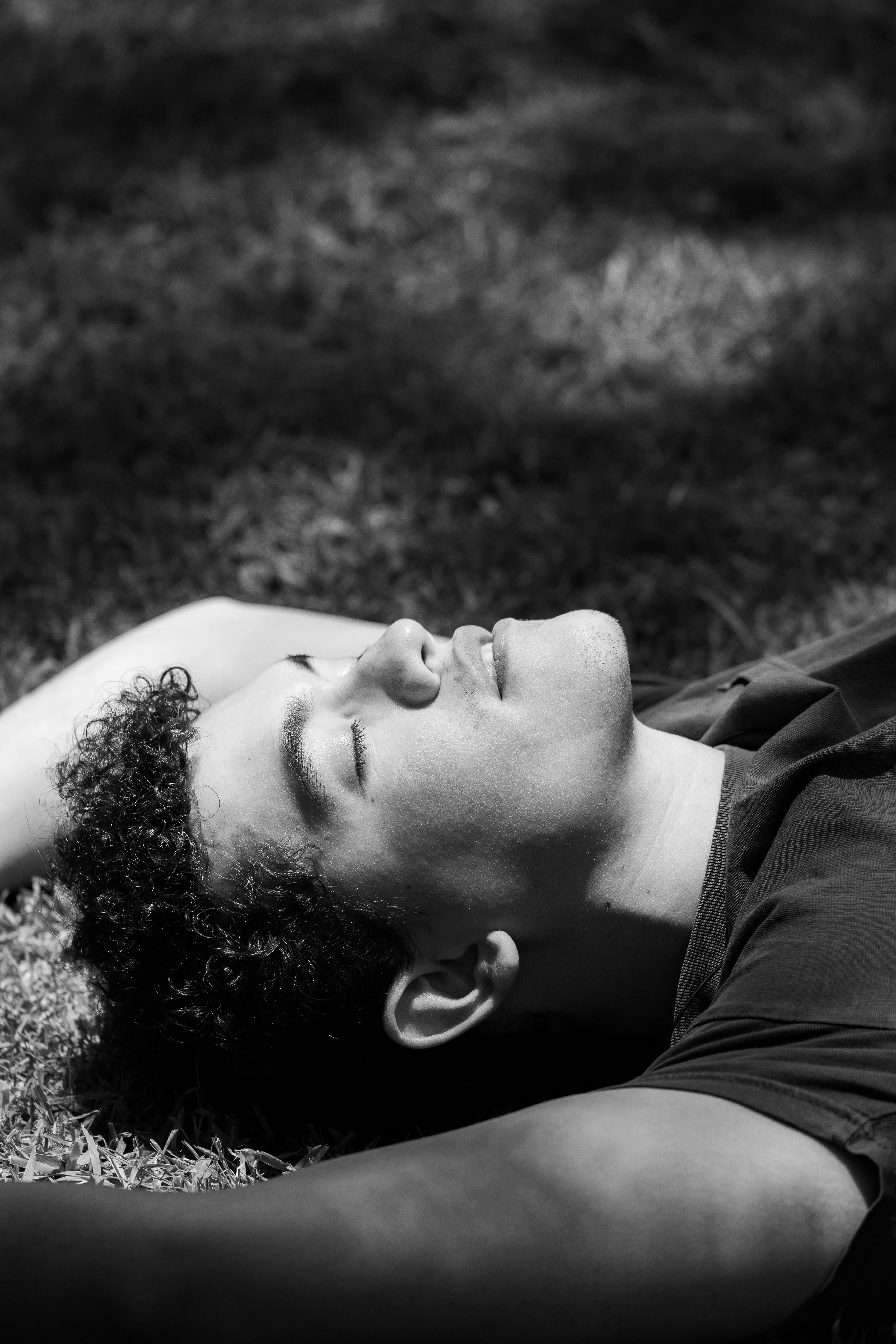 Young man resting on grass in black and white