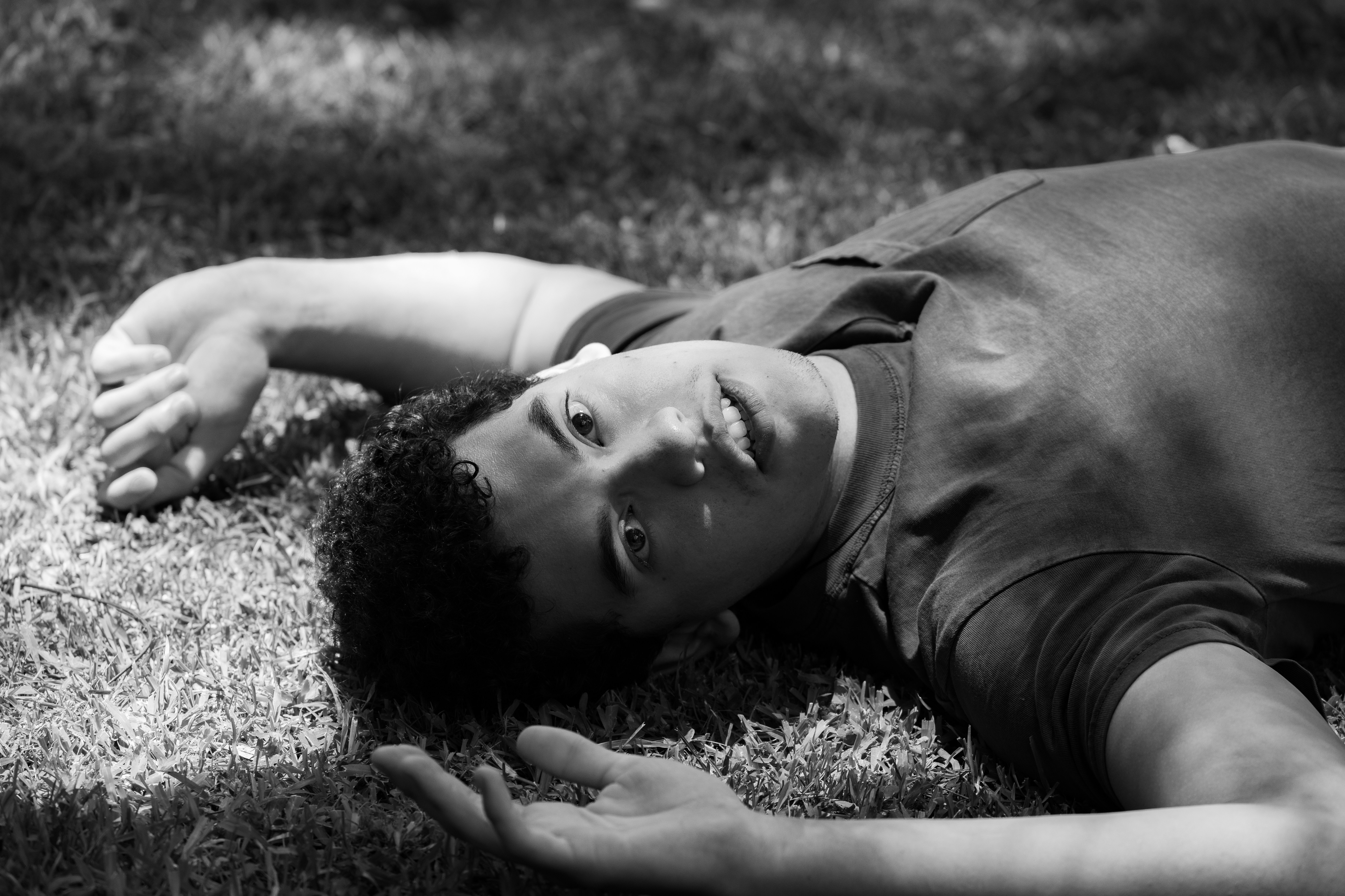 A person lies on grass in black and white