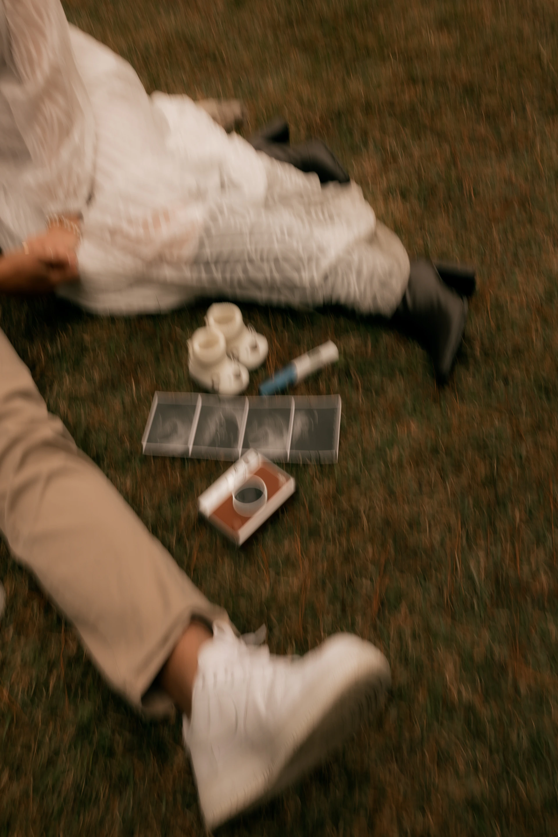 Two people relaxing on grass with craft supplies