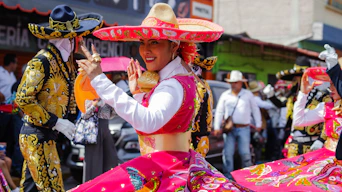 Smiling woman in vibrant mexican attire dancing at a celebration.