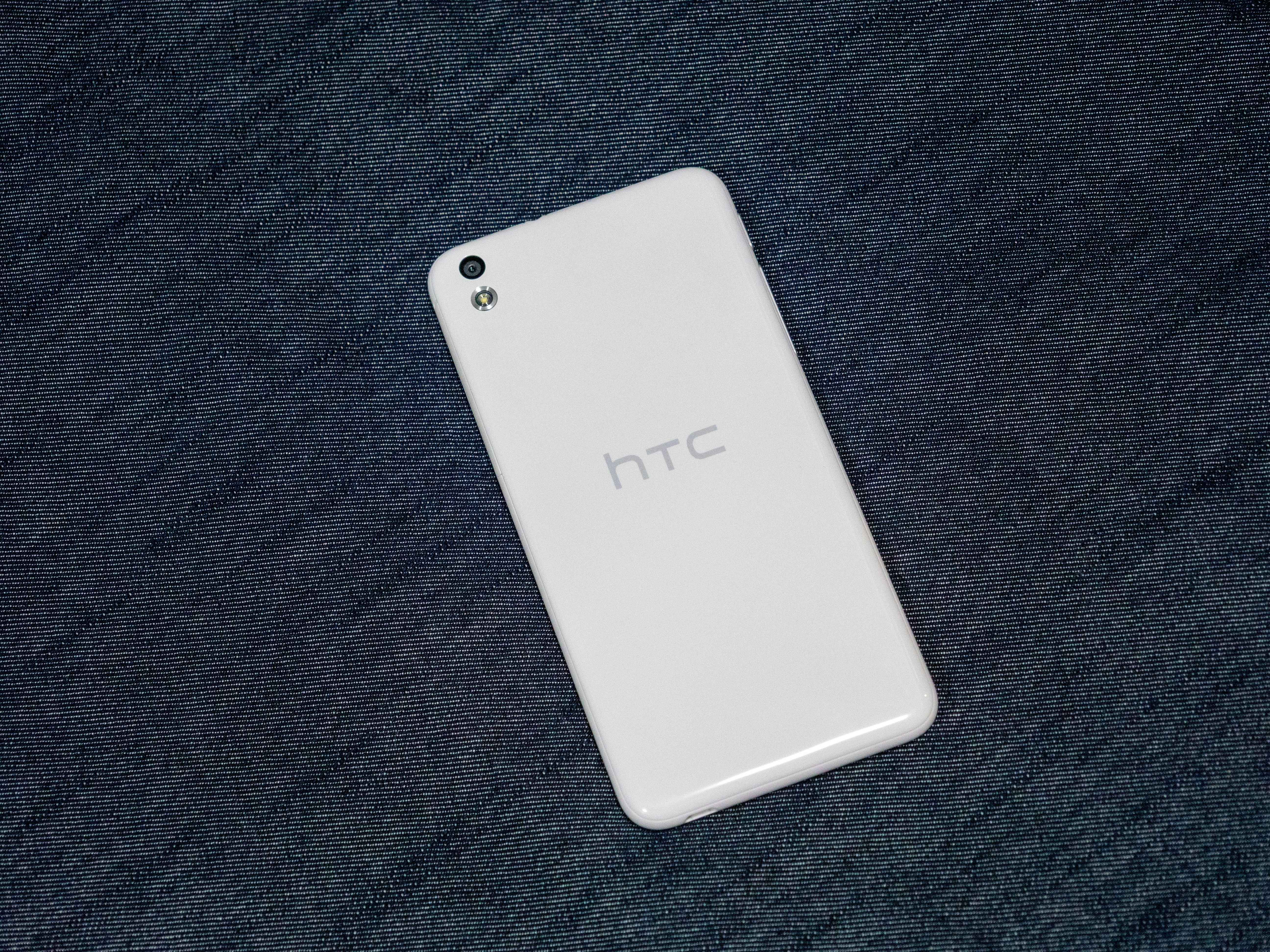 White htc smartphone on a dark textured background.