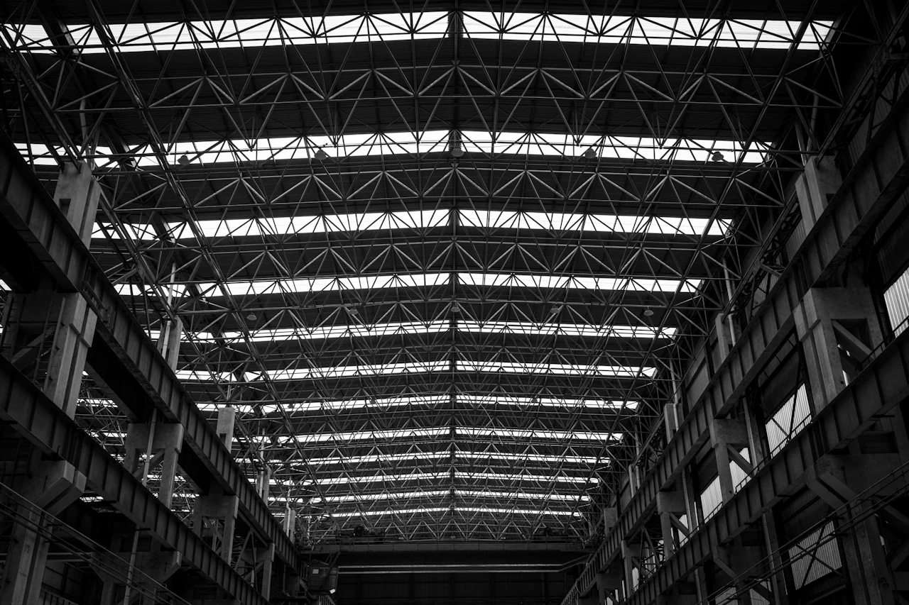 Struktur atap industri dengan skylight, difoto dari bawah dalam hitam putih