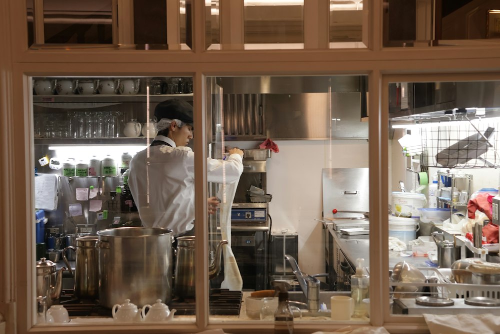 Restaurant cook working beside stockpots in an open professional kitchen