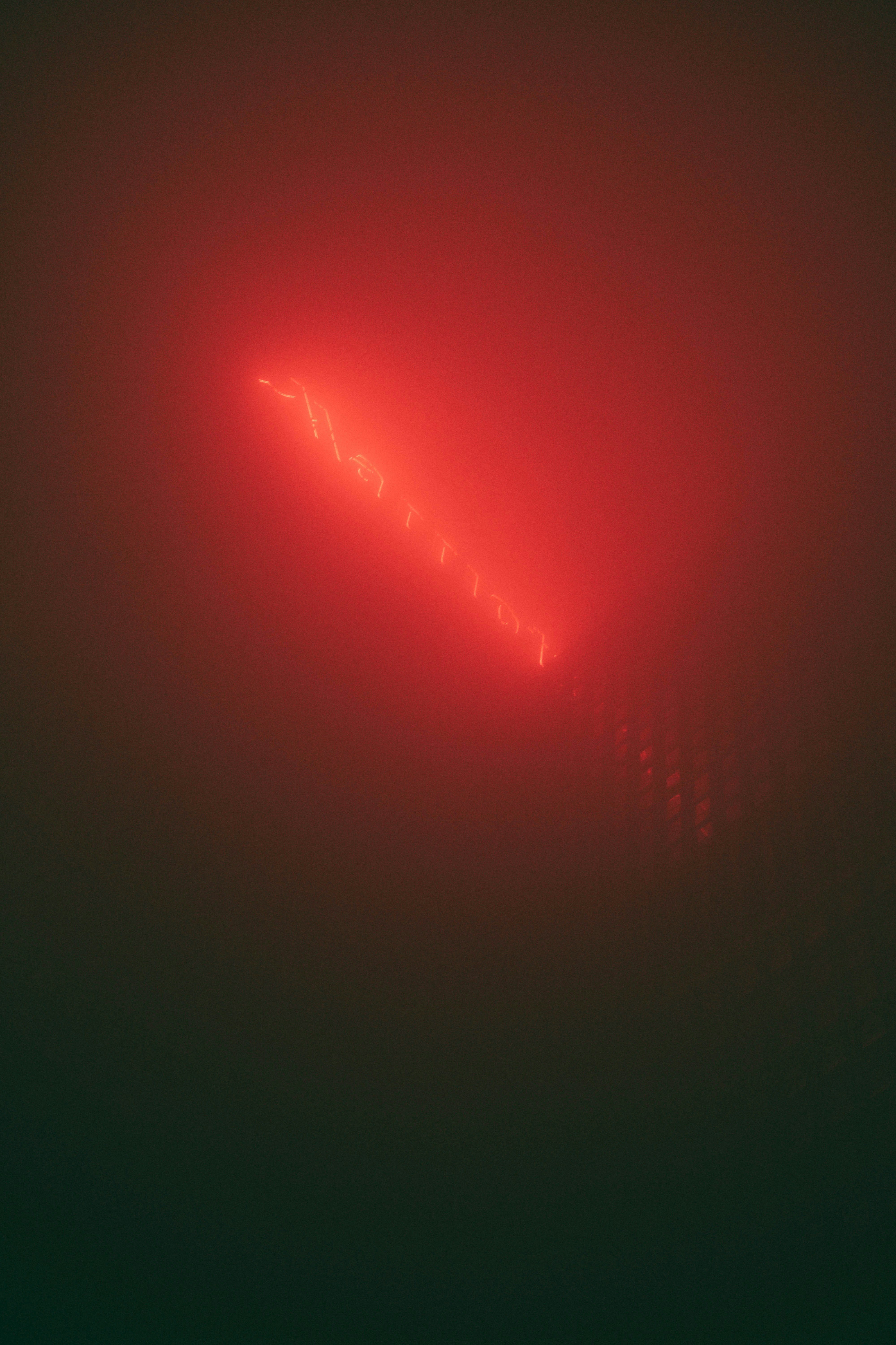Glowing red light forming a triangle on a dark background.