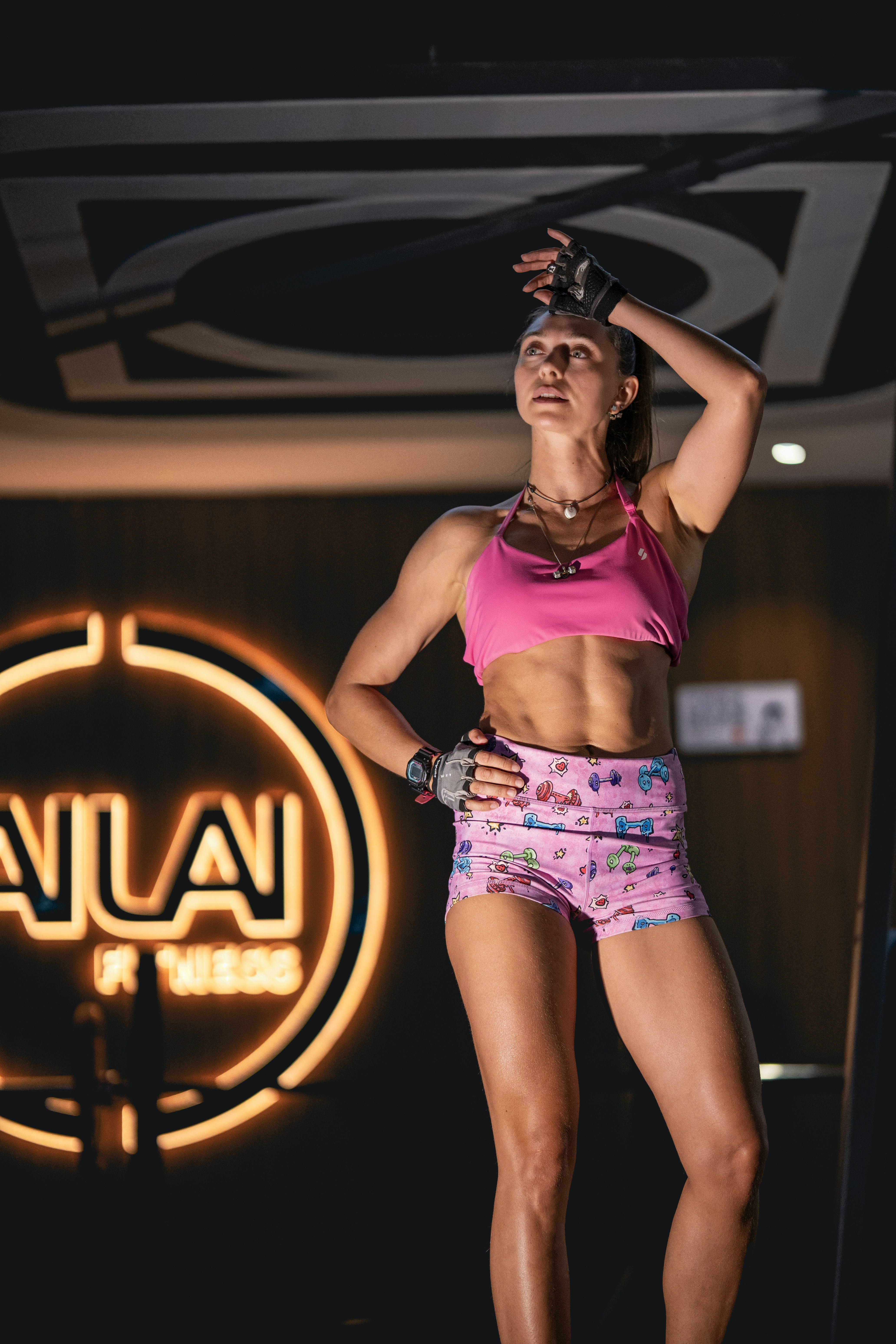 Fit woman wiping sweat after workout in gym