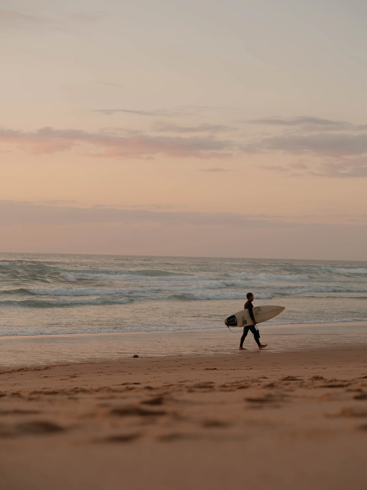 Surfer walking toward the waves