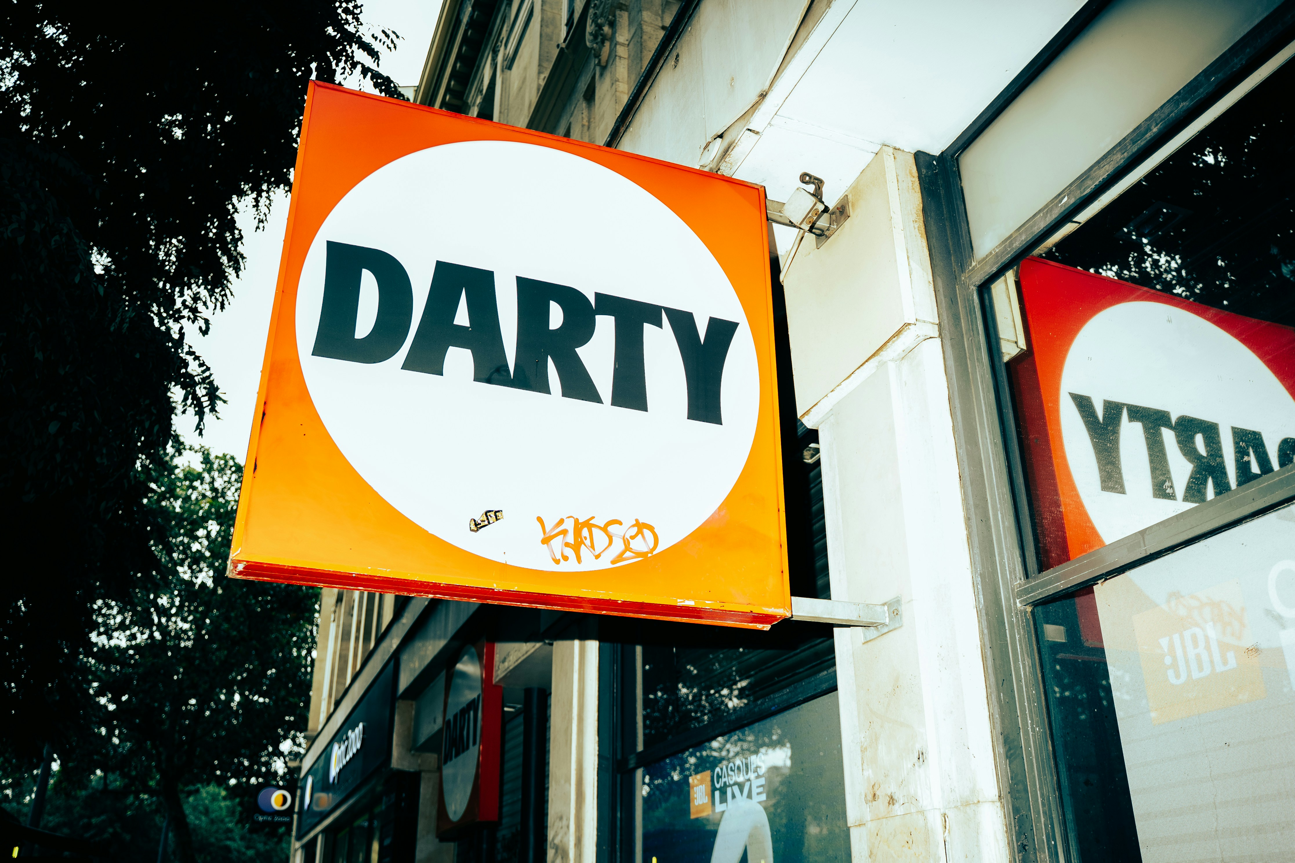 Cartel naranja y blanco de la tienda Darty en un edificio.