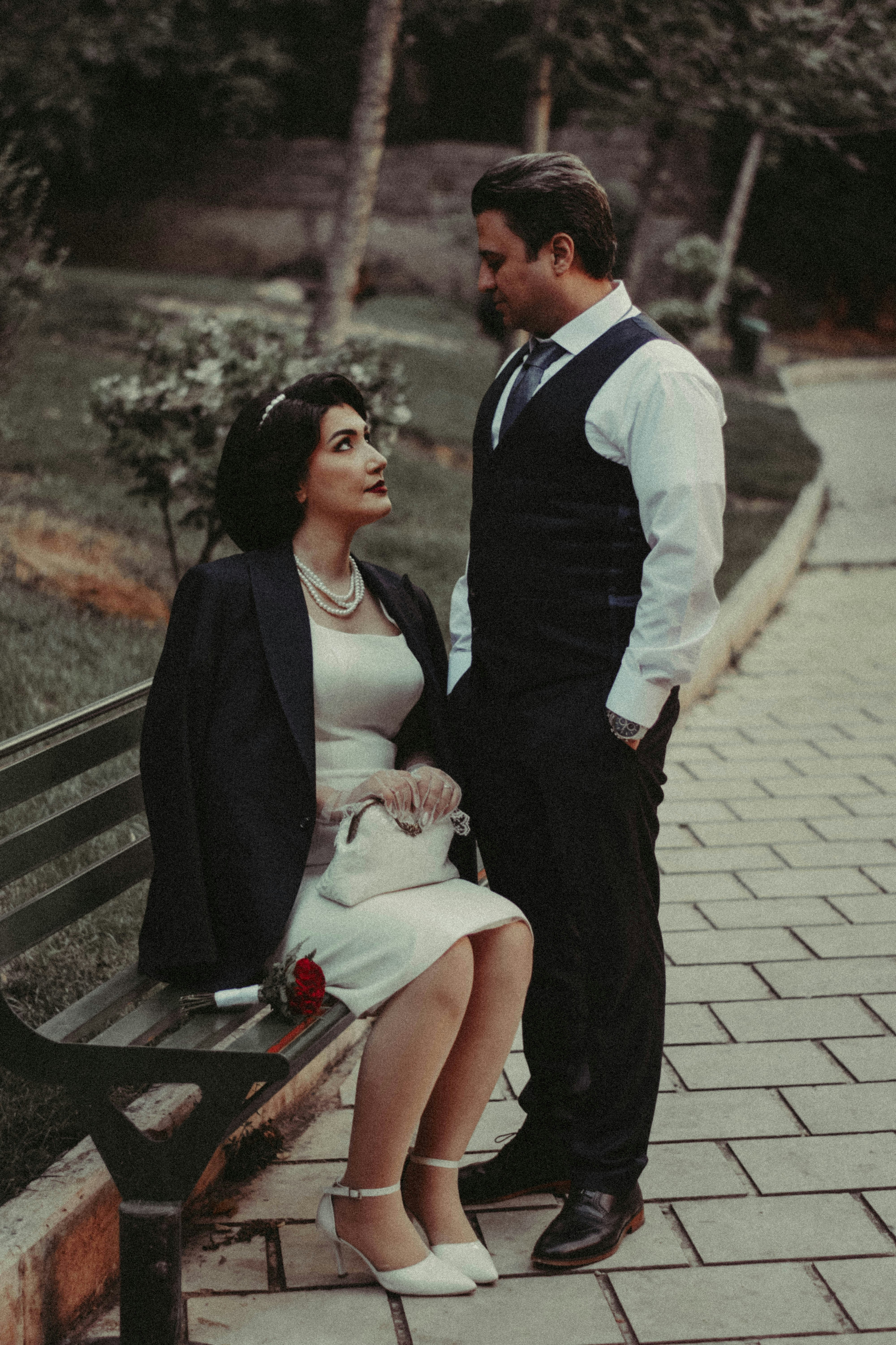Elegant couple looking at each other on a park bench