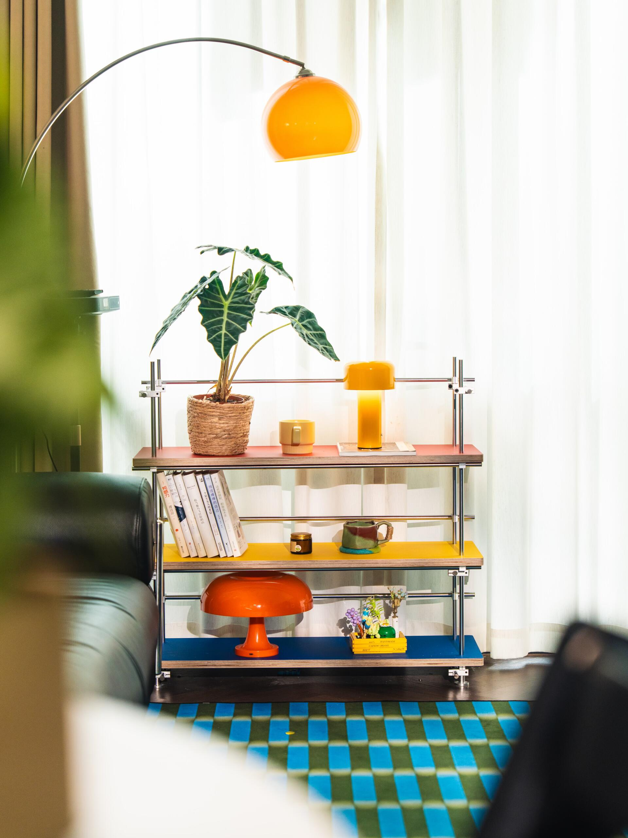 Une étagère vibrante et colorée avec des plantes et des lampes.