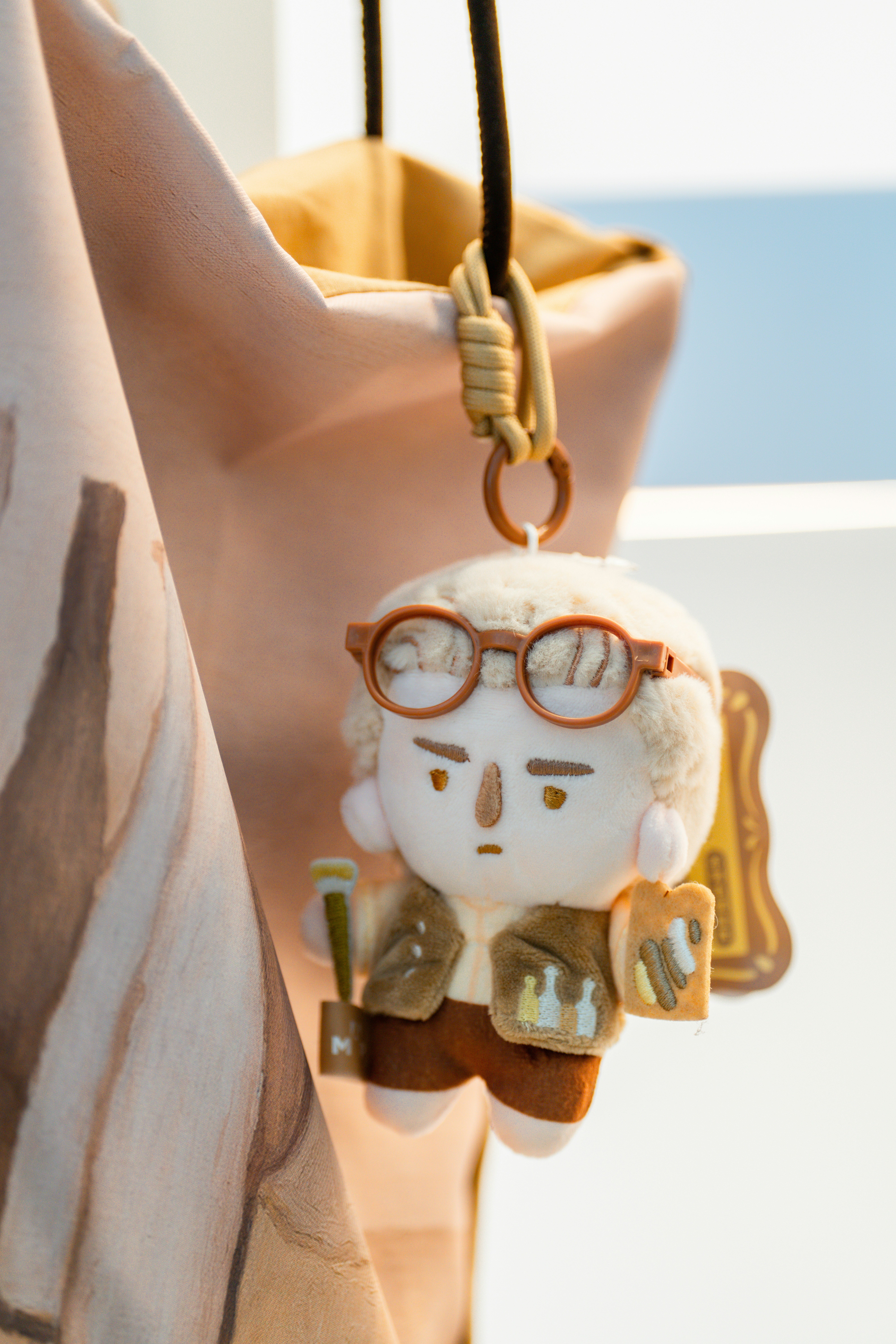 Un carino portachiavi di peluche con occhiali e libro.