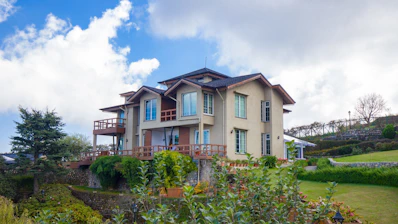 Elegant house with balconies nestled on a verdant hillside.