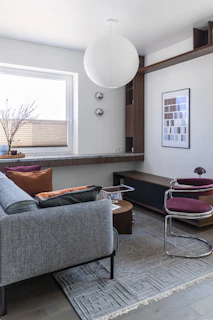 Stylish living room with sofa, window, and round pendant lamp.