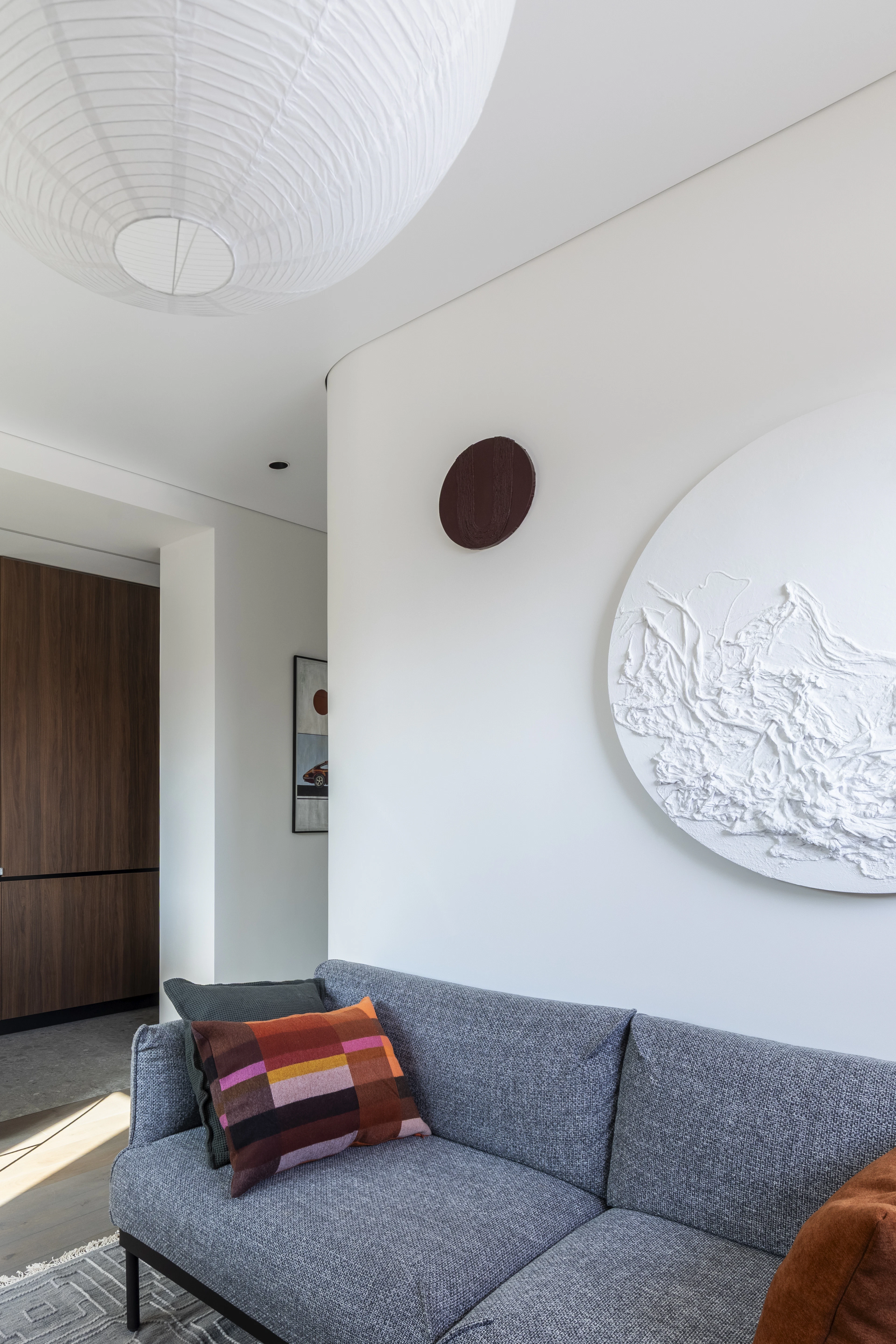 A calm living room with a white relief artwork