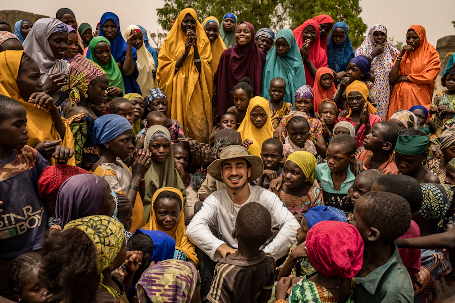 A man smiling among children and women from the community