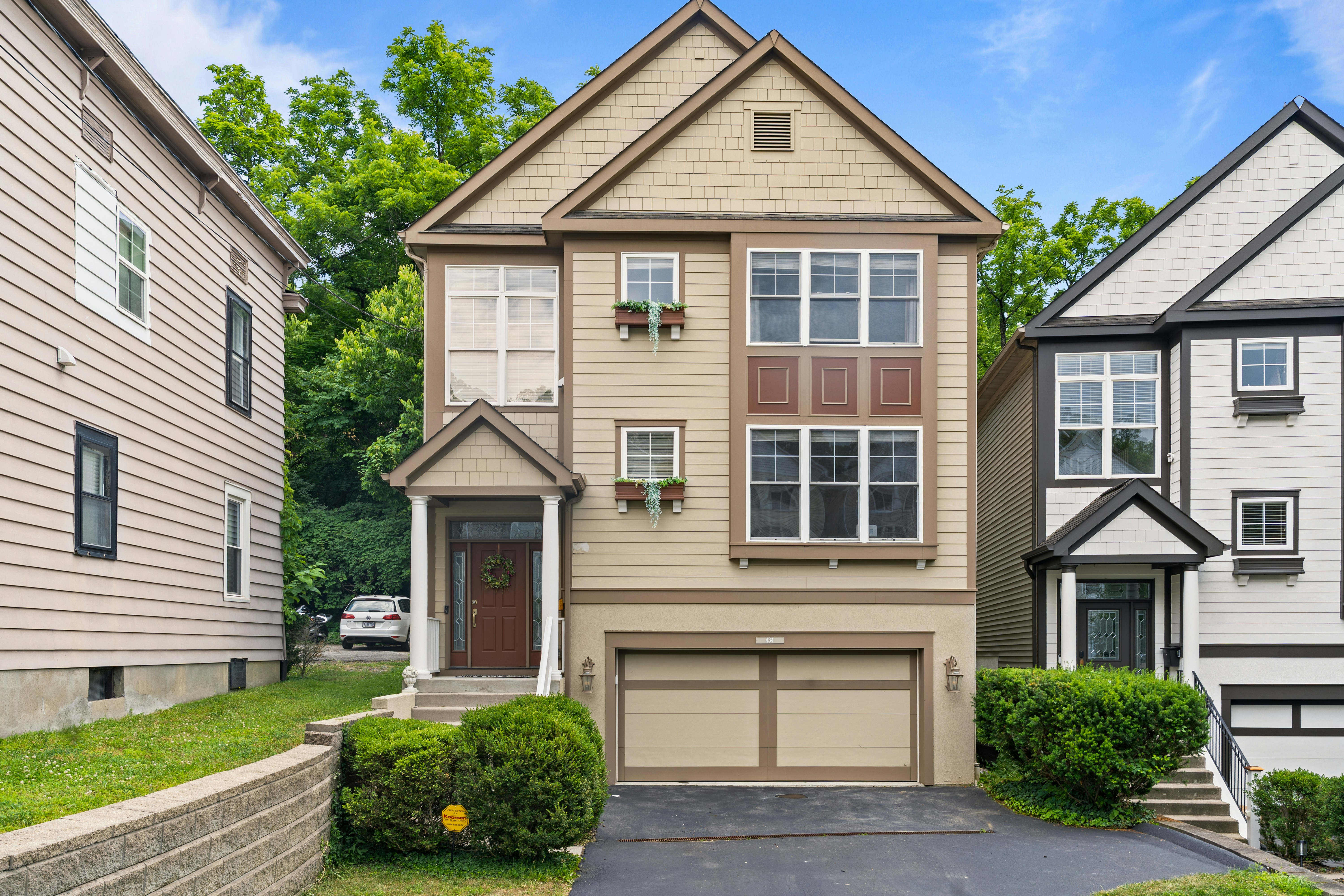 A beige multi-storey house with a garage and green landscaping, the kind of listing buyers must price-check against comparable sales