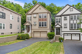 Three residential houses with driveways and green trees.