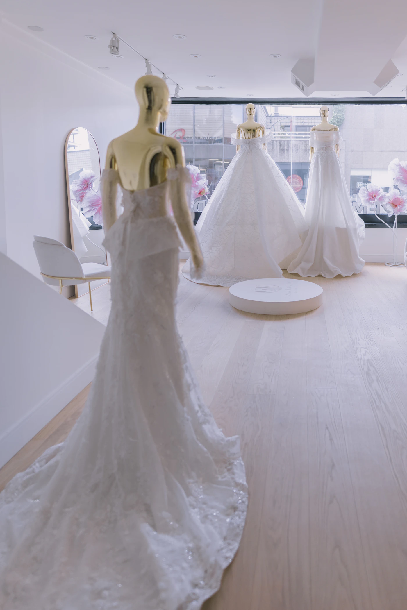 Best tailors for wedding dress emergencies near me — A tailor pins the hem of a bride's wedding dress during a fitting.