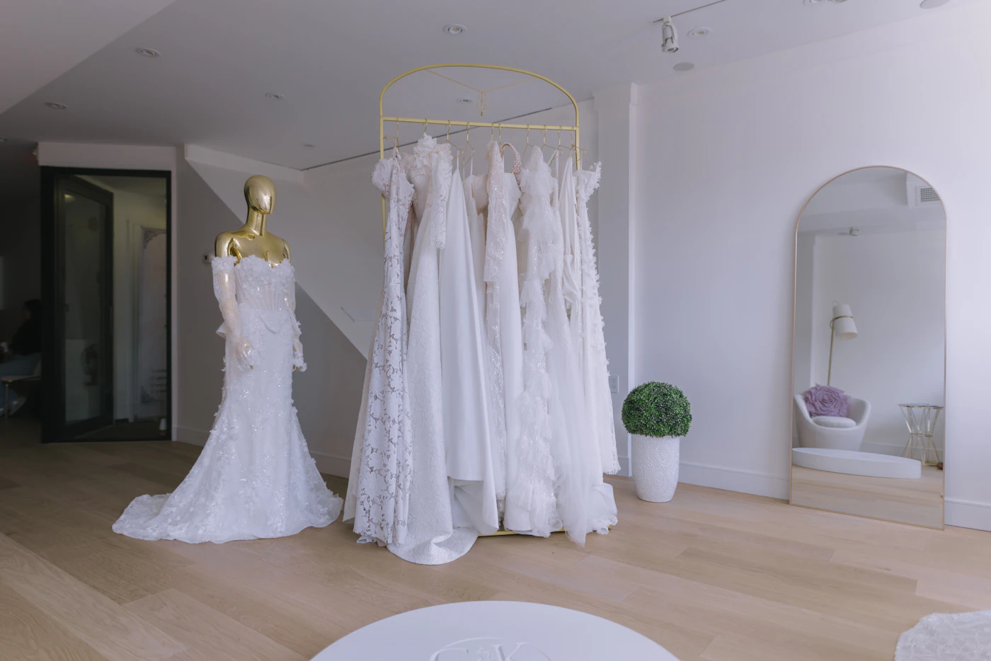 Inclusive size charts for bridal boutiques near me — A bride smiling in a bridal salon fitting room.