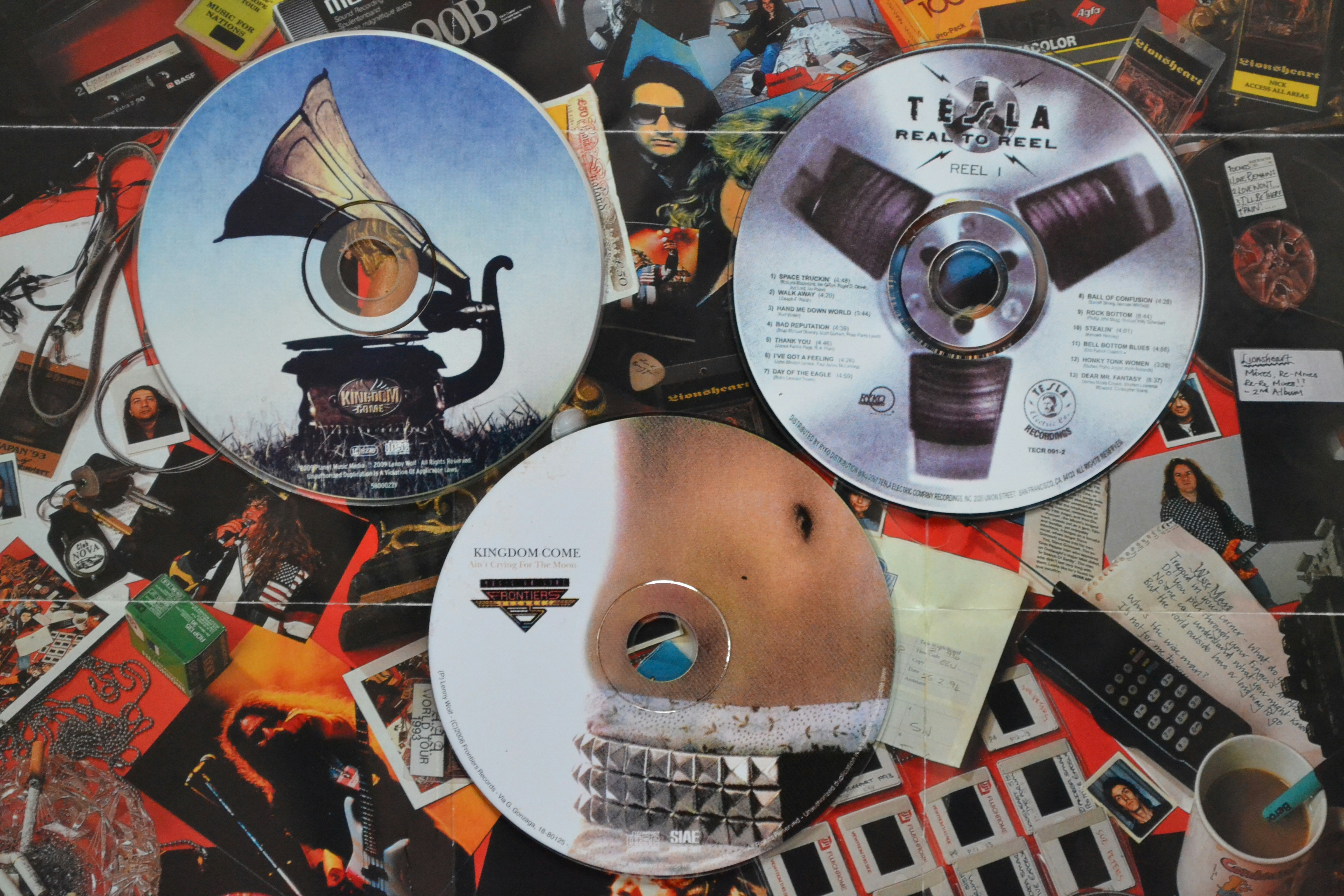 Três CDs com designs únicos em um fundo movimentado.
