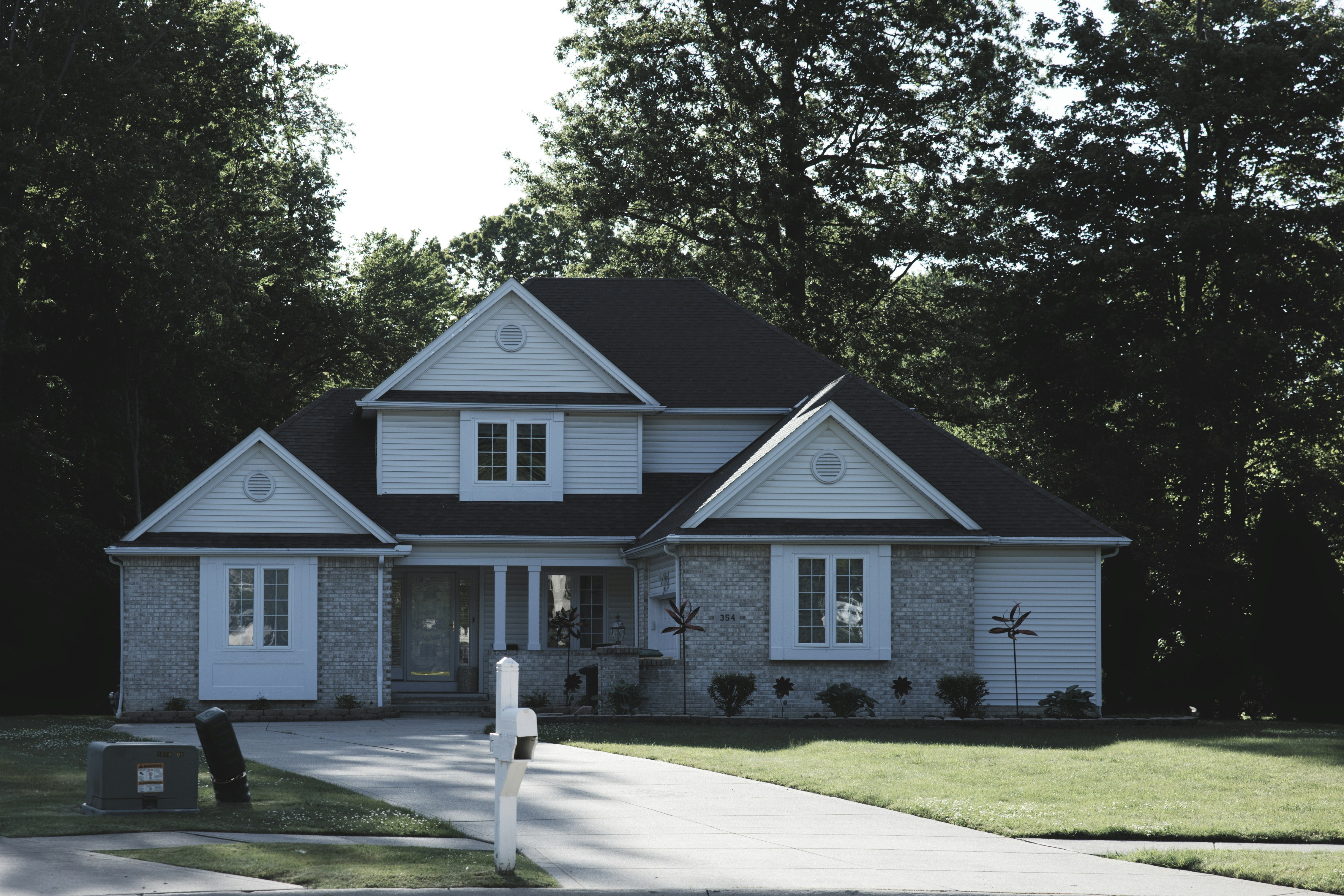 suburban house exterior - Modern suburban house with a green lawn and trees.