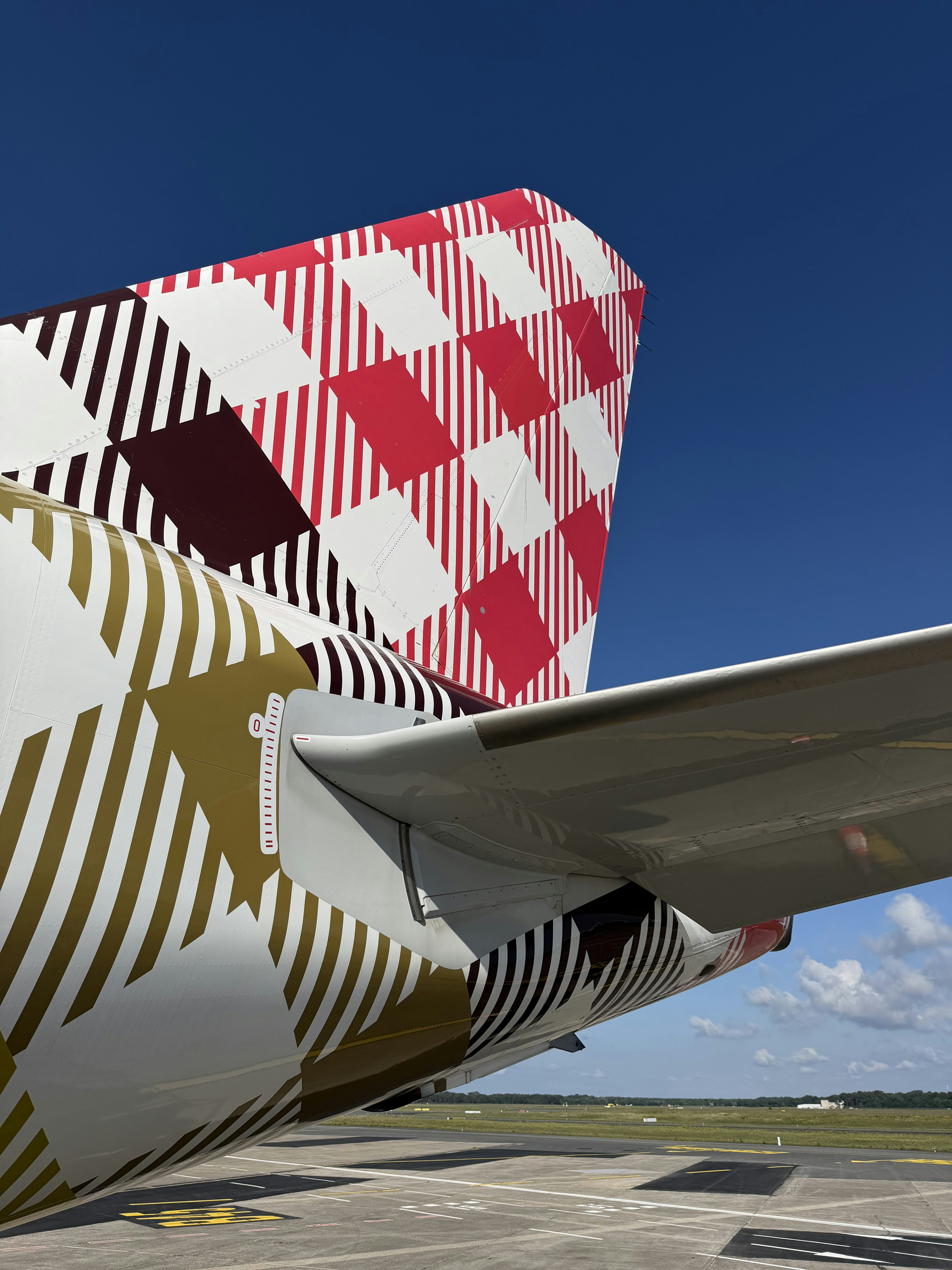 Airplane tail featuring a unique red and gold checkered design.