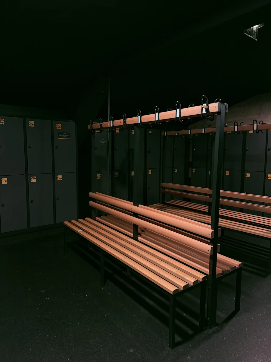 A dark locker room with wooden benches