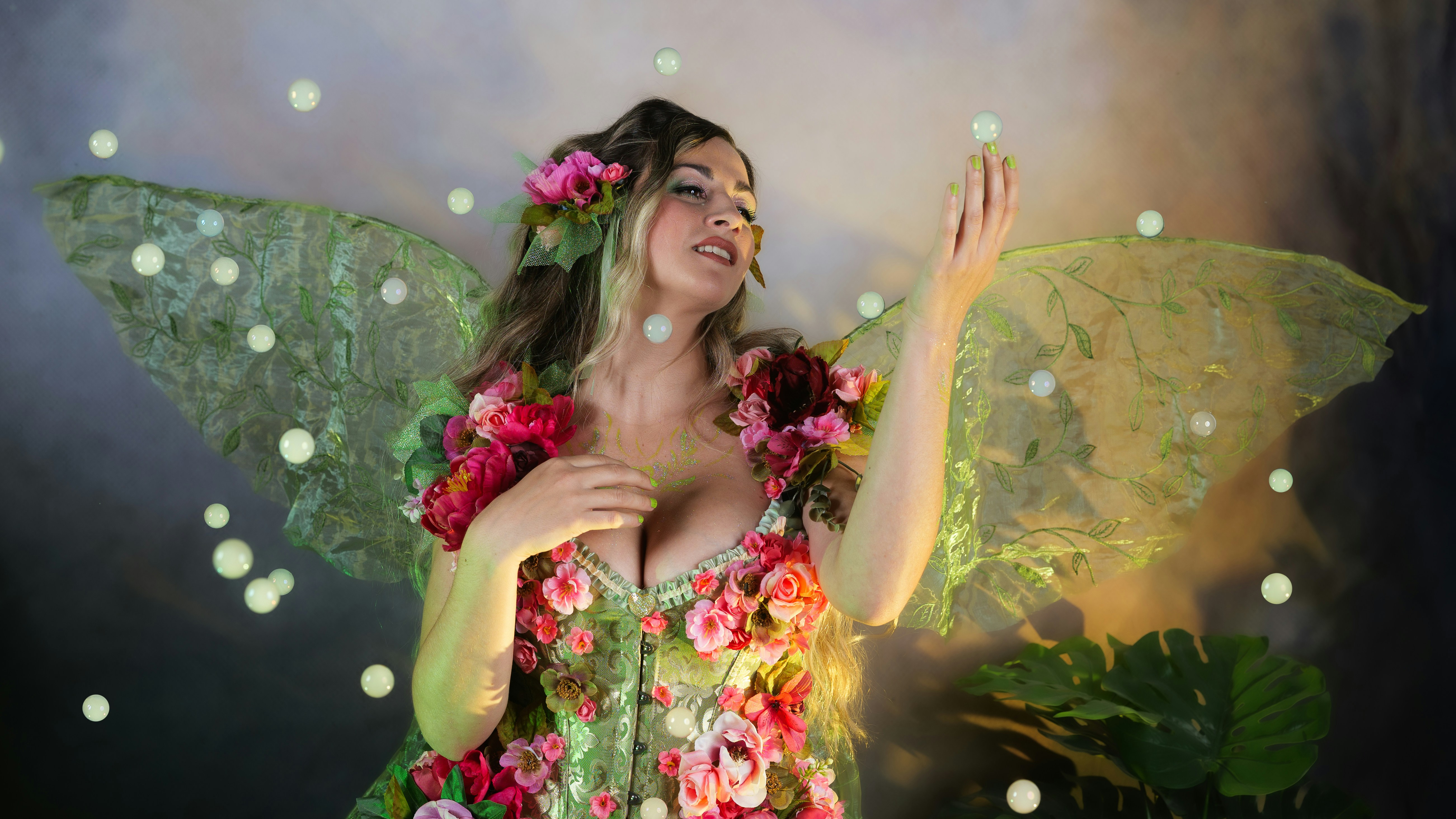 Mujer encantadora vestida de hada de las flores con orbes brillantes.