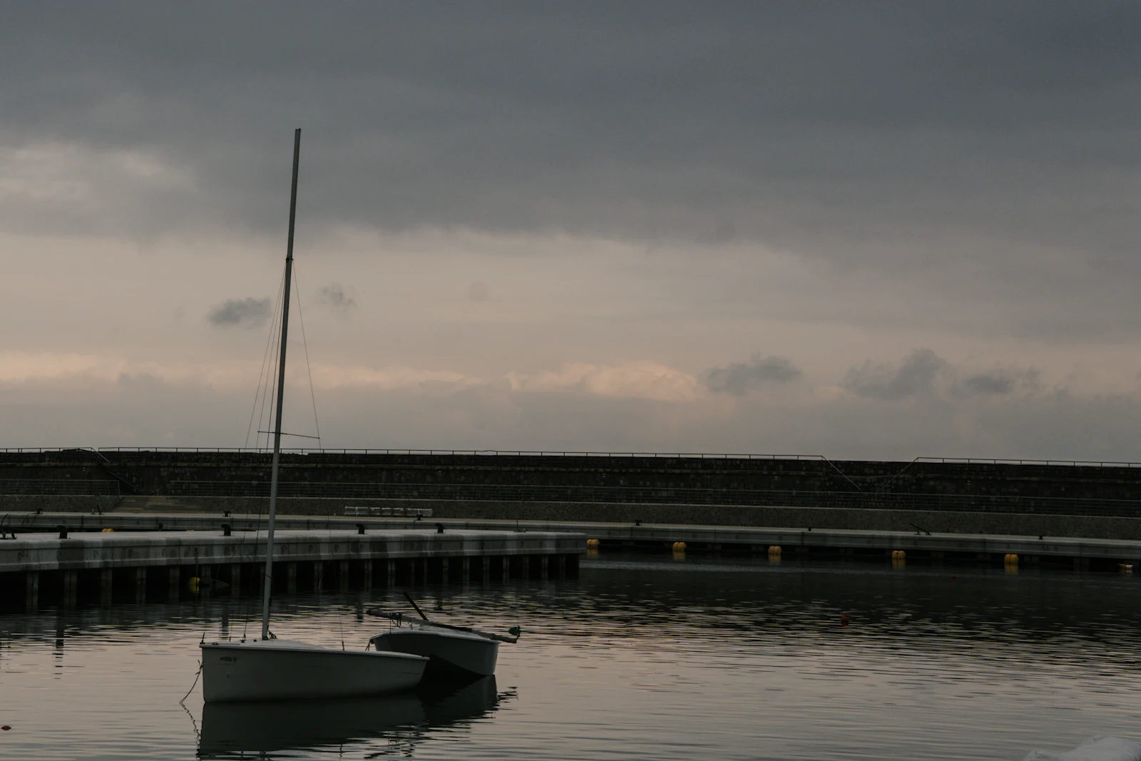 Boats moored in a calm harbor at dusk