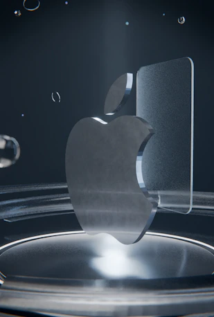 A clear glass apple logo on a reflective dark surface