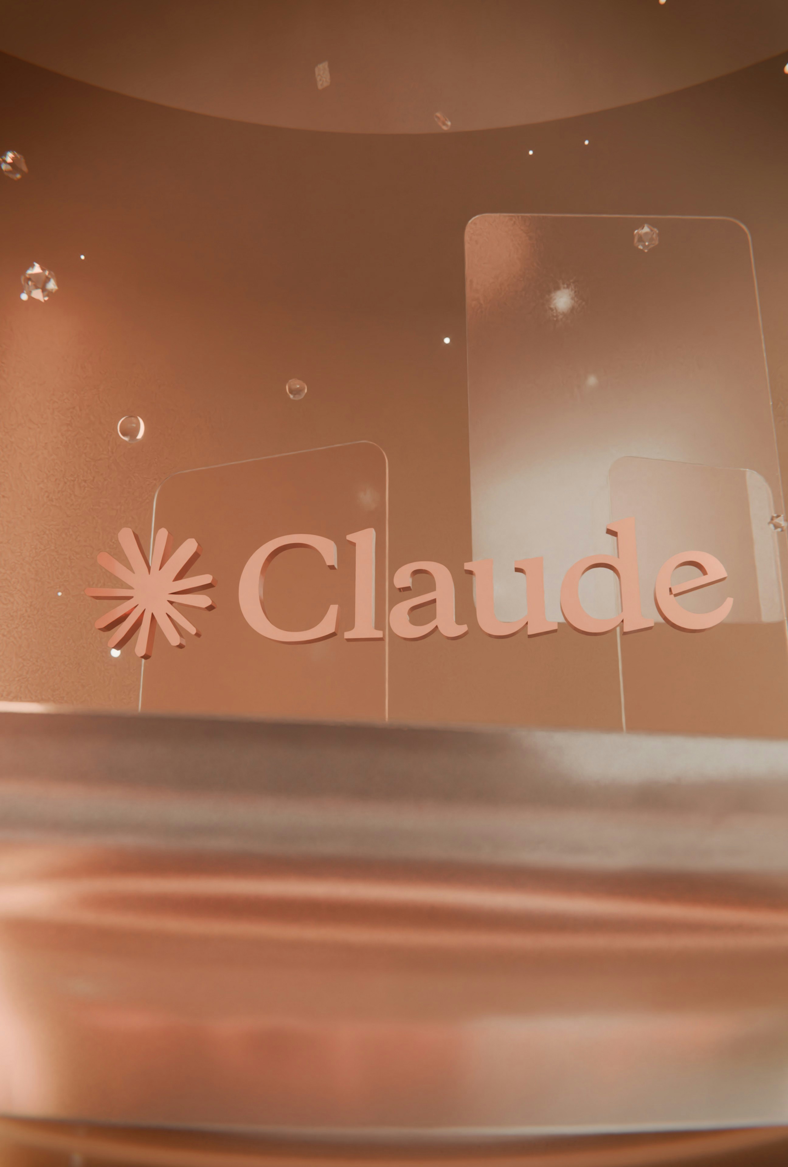 Rose-gold claudel logo with clear acrylic panels and bubbles.
