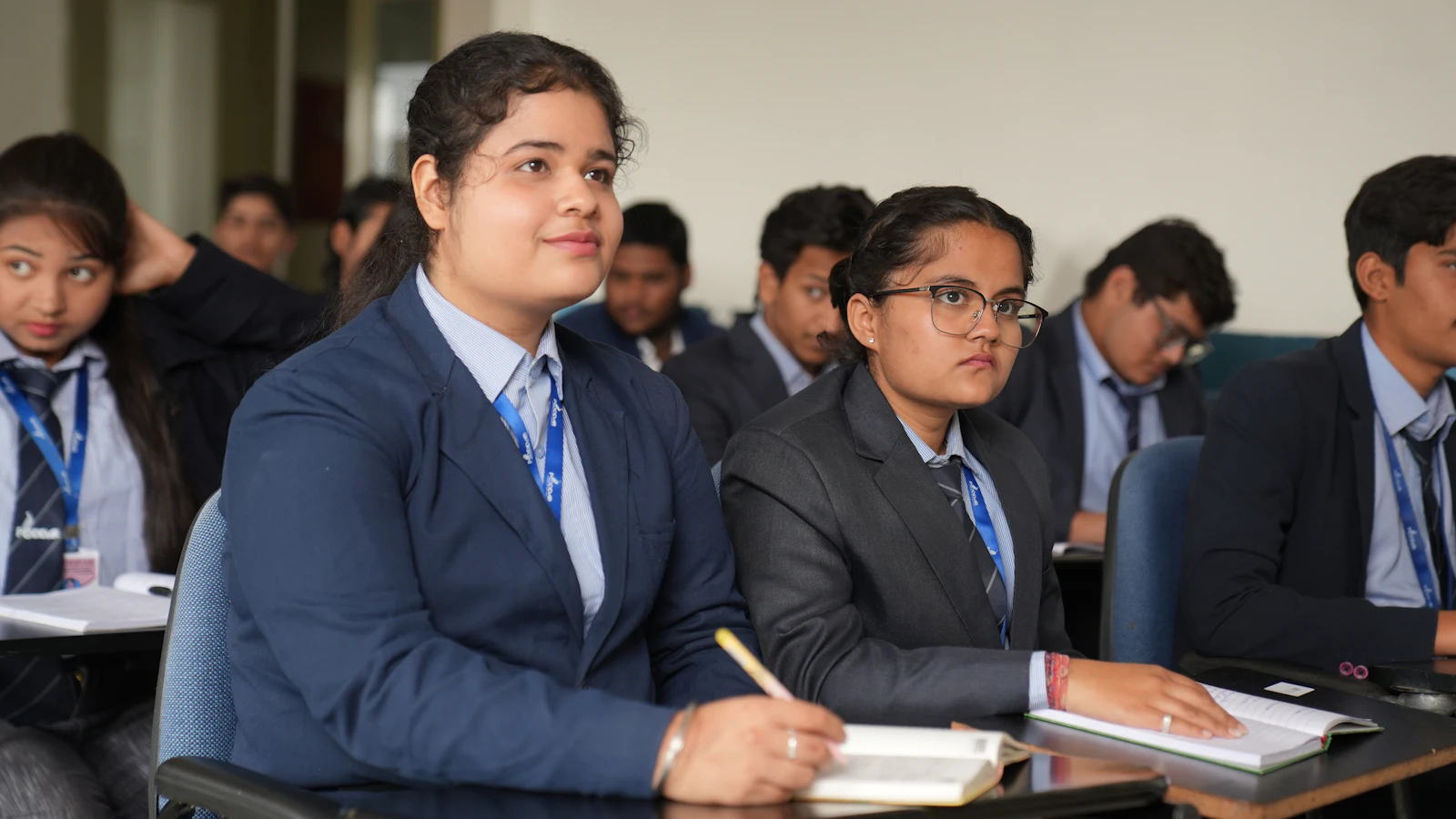 Attentive students in blazers taking notes in a VIDYA class