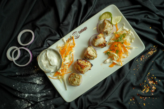 Creamy white malai chicken tikka with mint-yogurt dip and salad