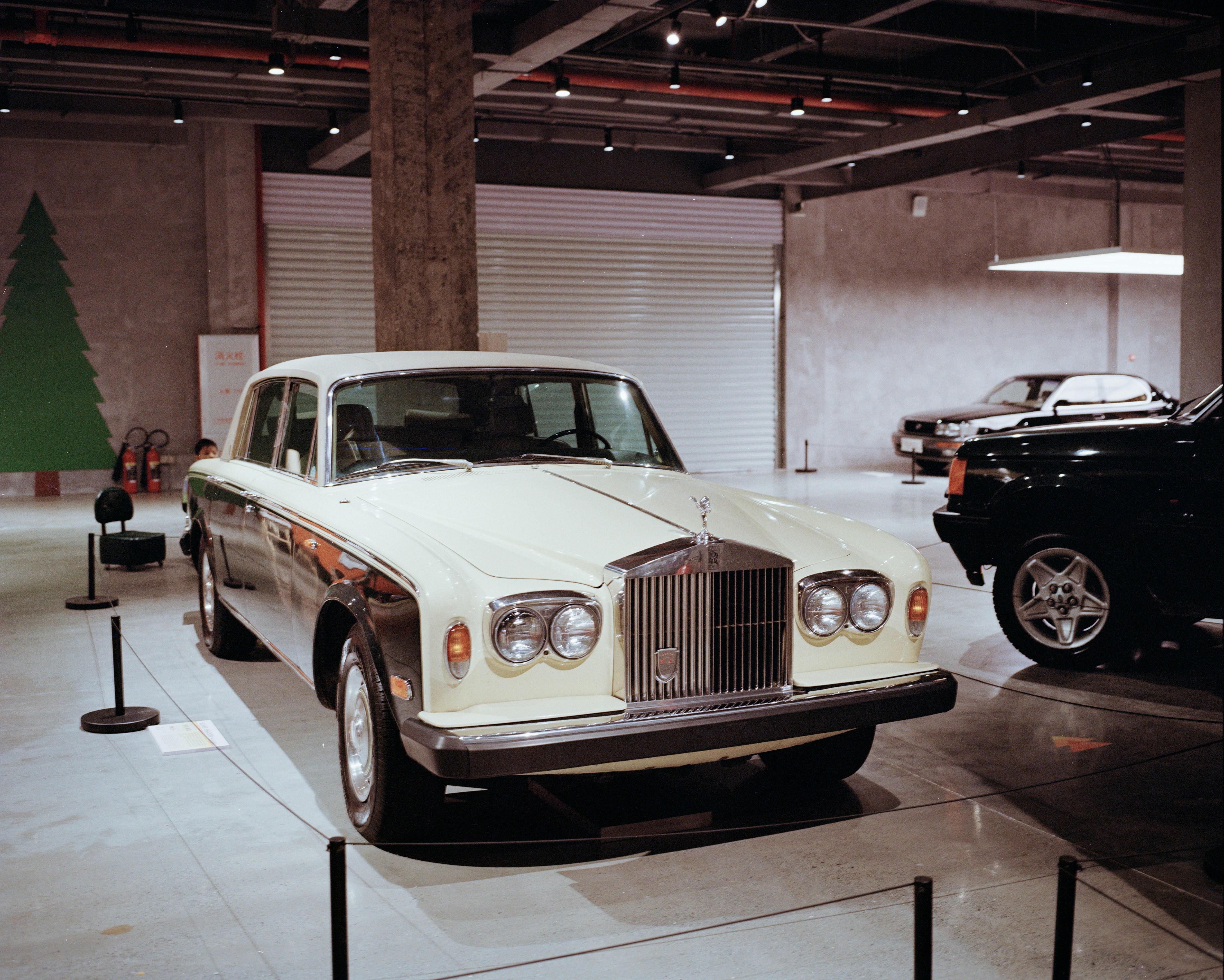 A classic white rolls-royce car displayed indoors.