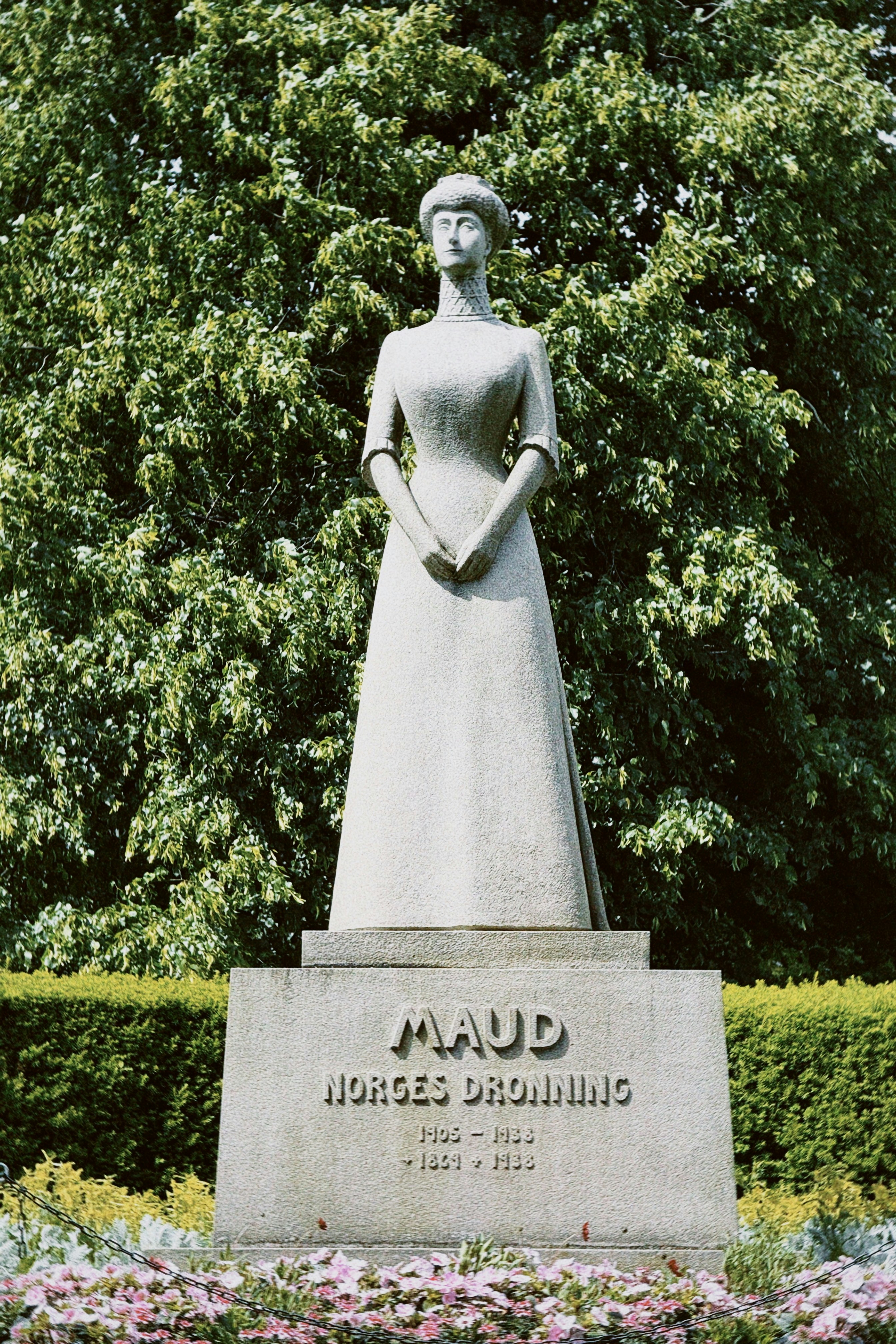 Stone statue of queen maud of norway in a garden