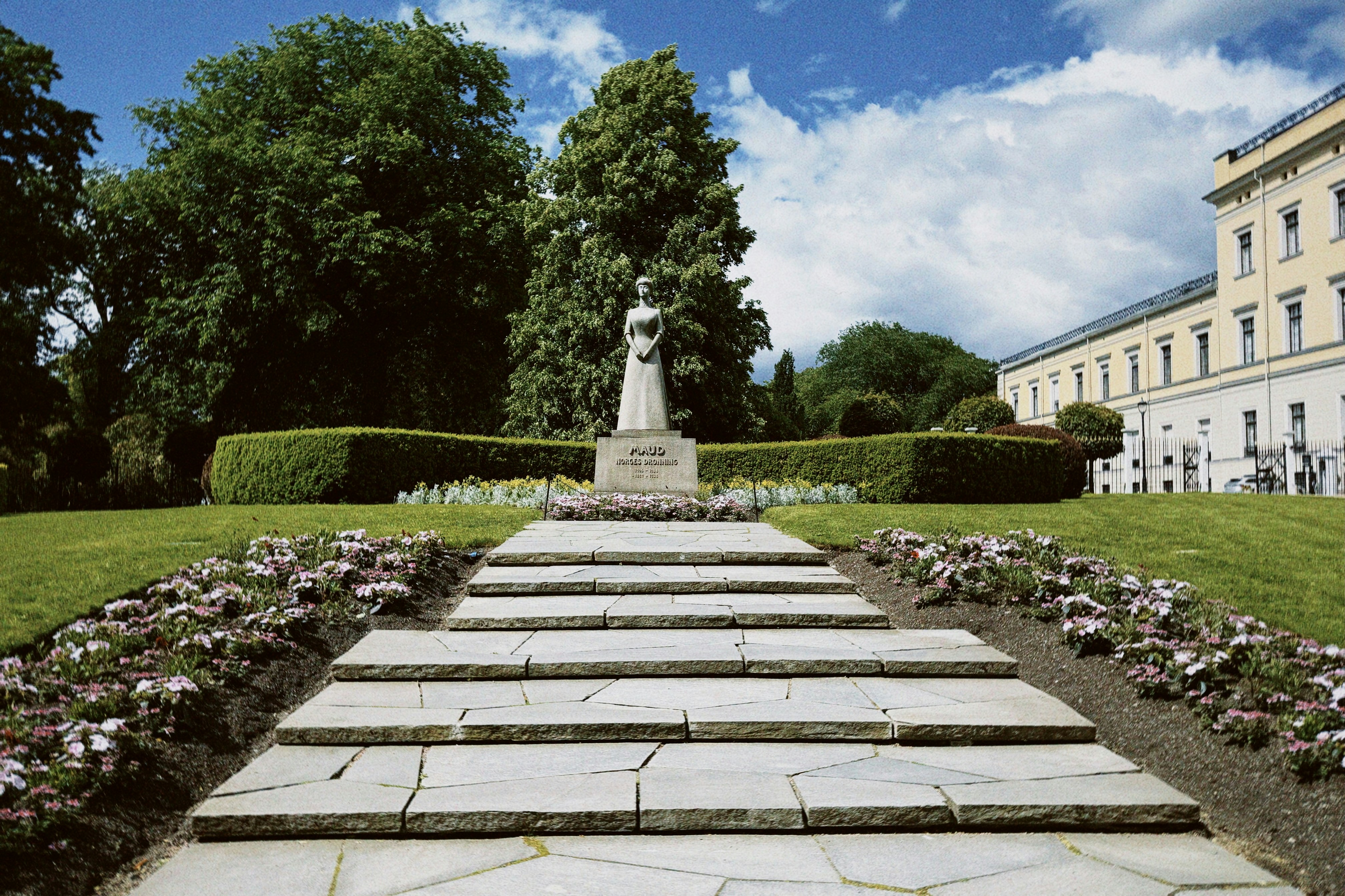Stone staircase leading to a statue in a formal garden