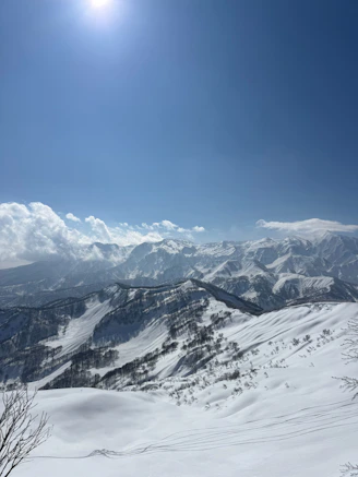 Vast snow-covered mountains bathed in bright sunlight.