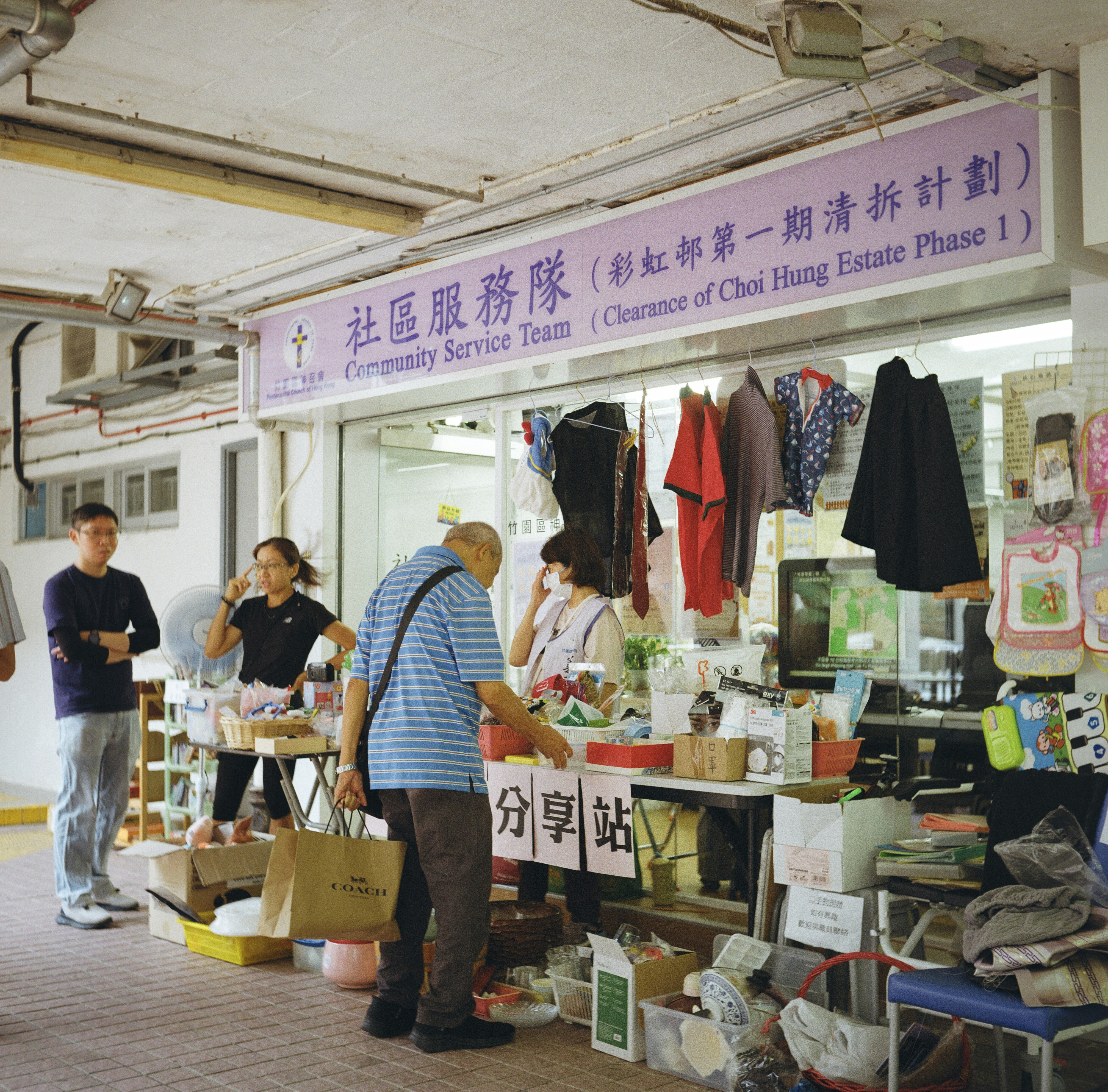 People browse items at a community service team stall.